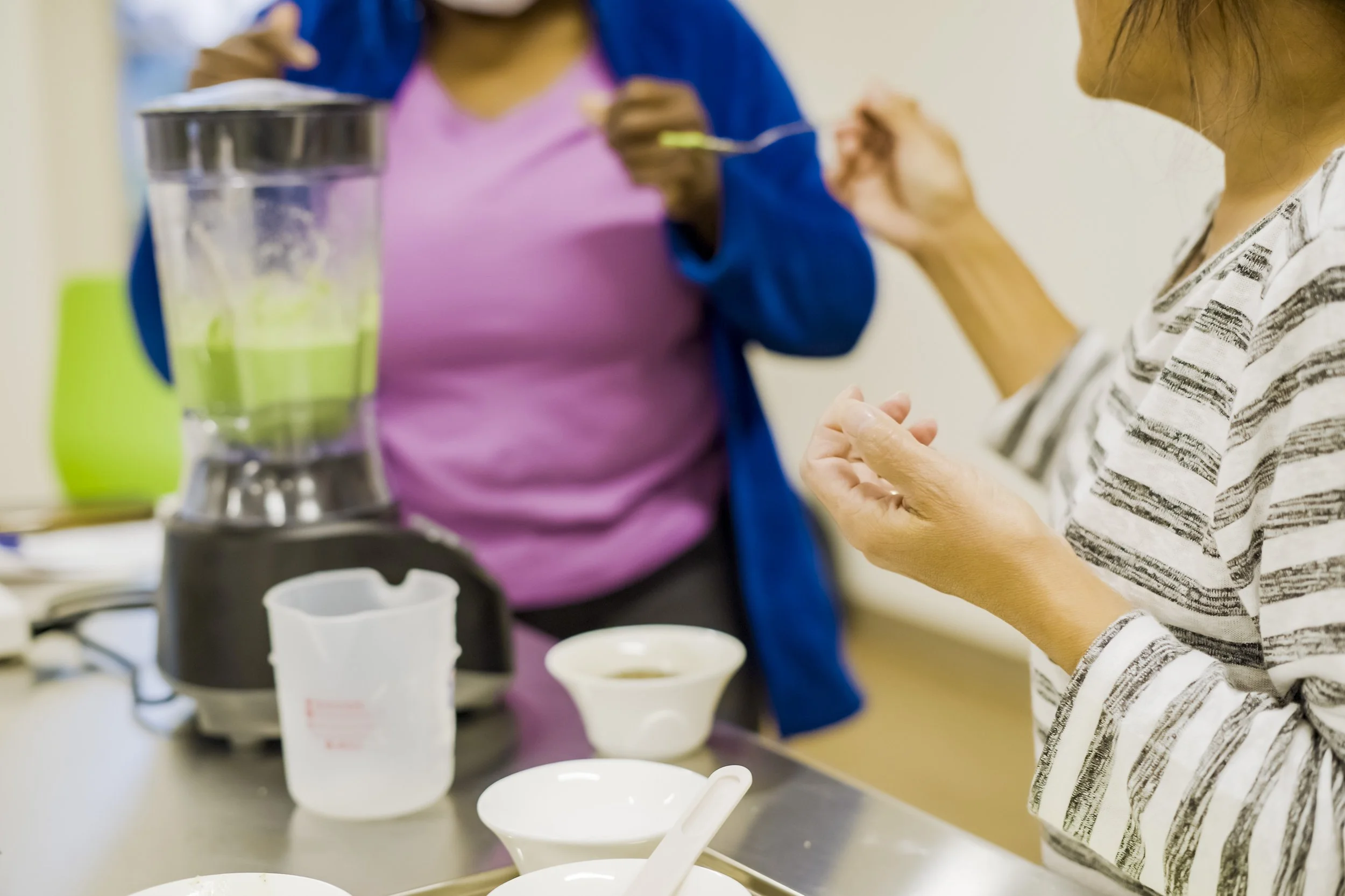 People preparing or serving food or drinks in a kitchen or cafe setting.