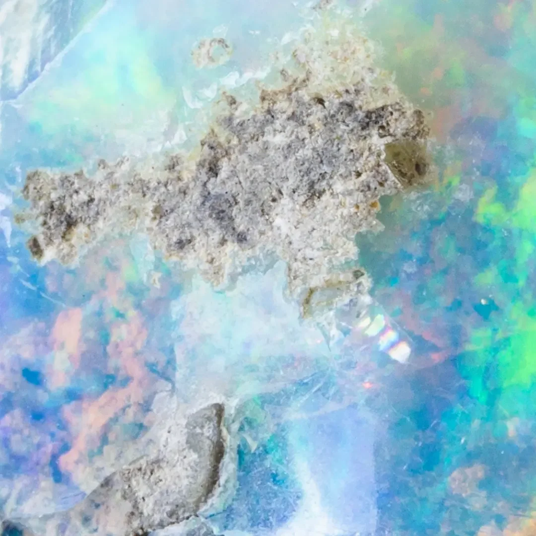Close-up of iridescent blue and green opal stone. Centred Wellness psychotherapist