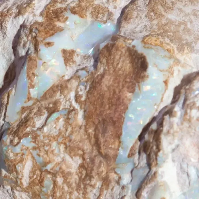 Close-up of a rough iridescent opal and rock. Centred Wellness therapy