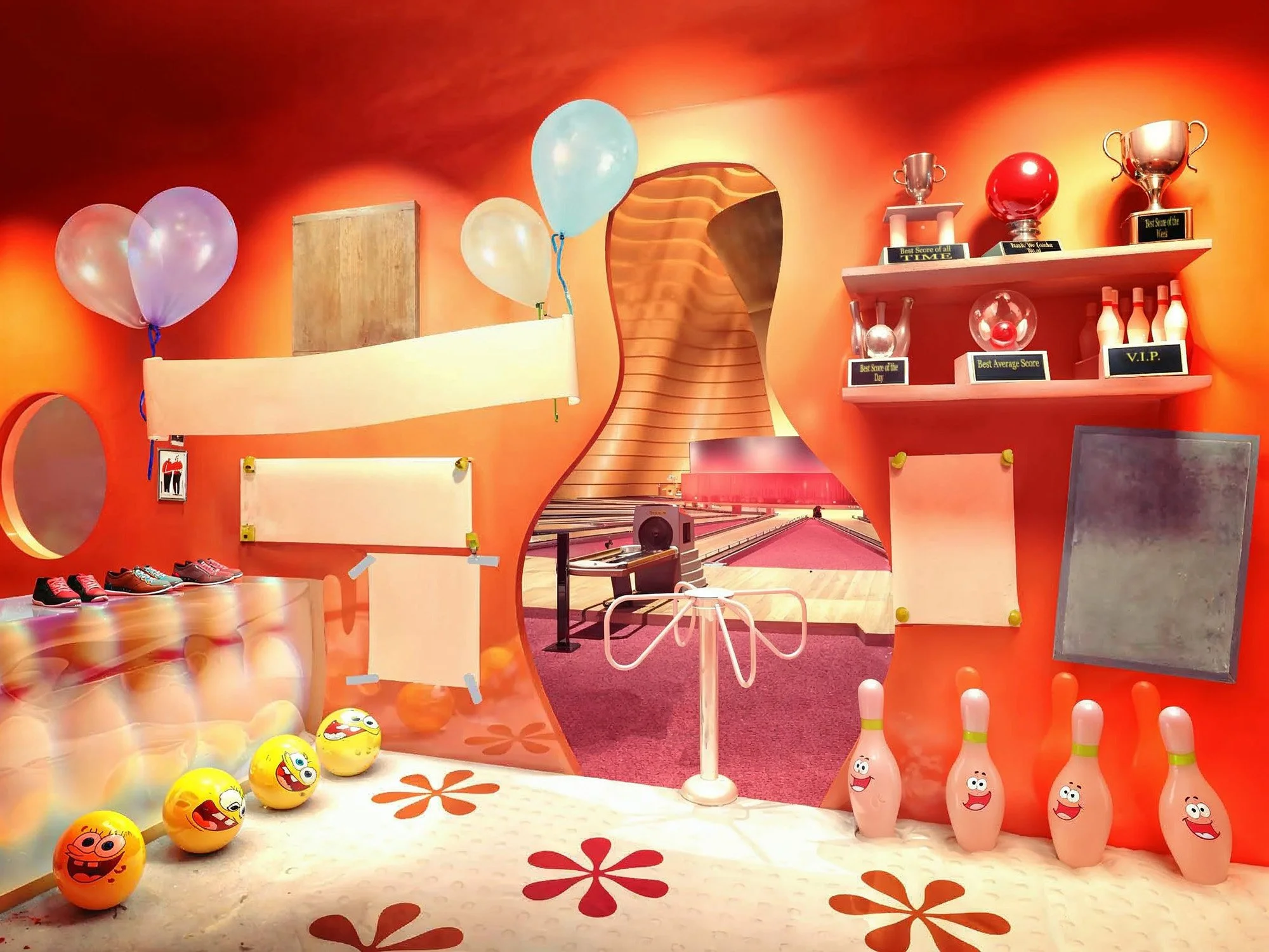 Colorful bowling alley with bowling balls, pins with cartoon faces, and trophies on shelves, decorated with balloons, and a view of the bowling lanes through an irregularly shaped opening.