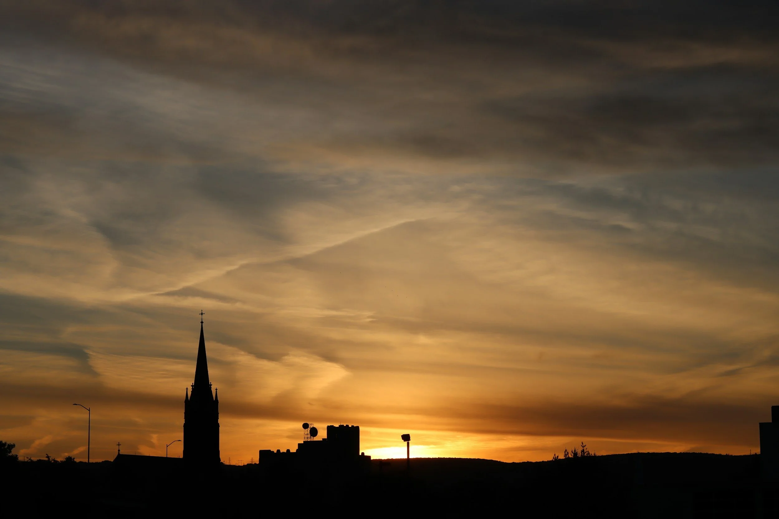 Church steeple silhouetted against an evening sky over the Wyoming Valley