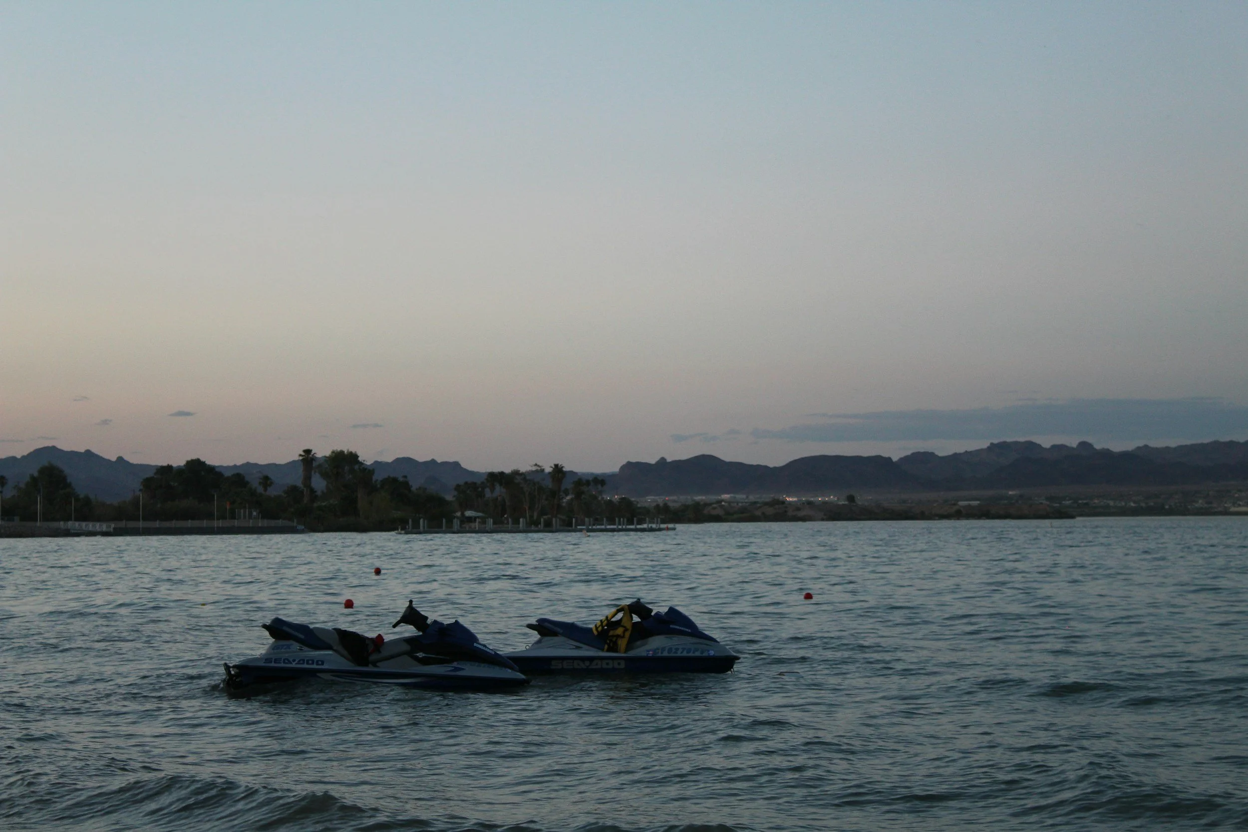 Jet skis on a lake at dusk