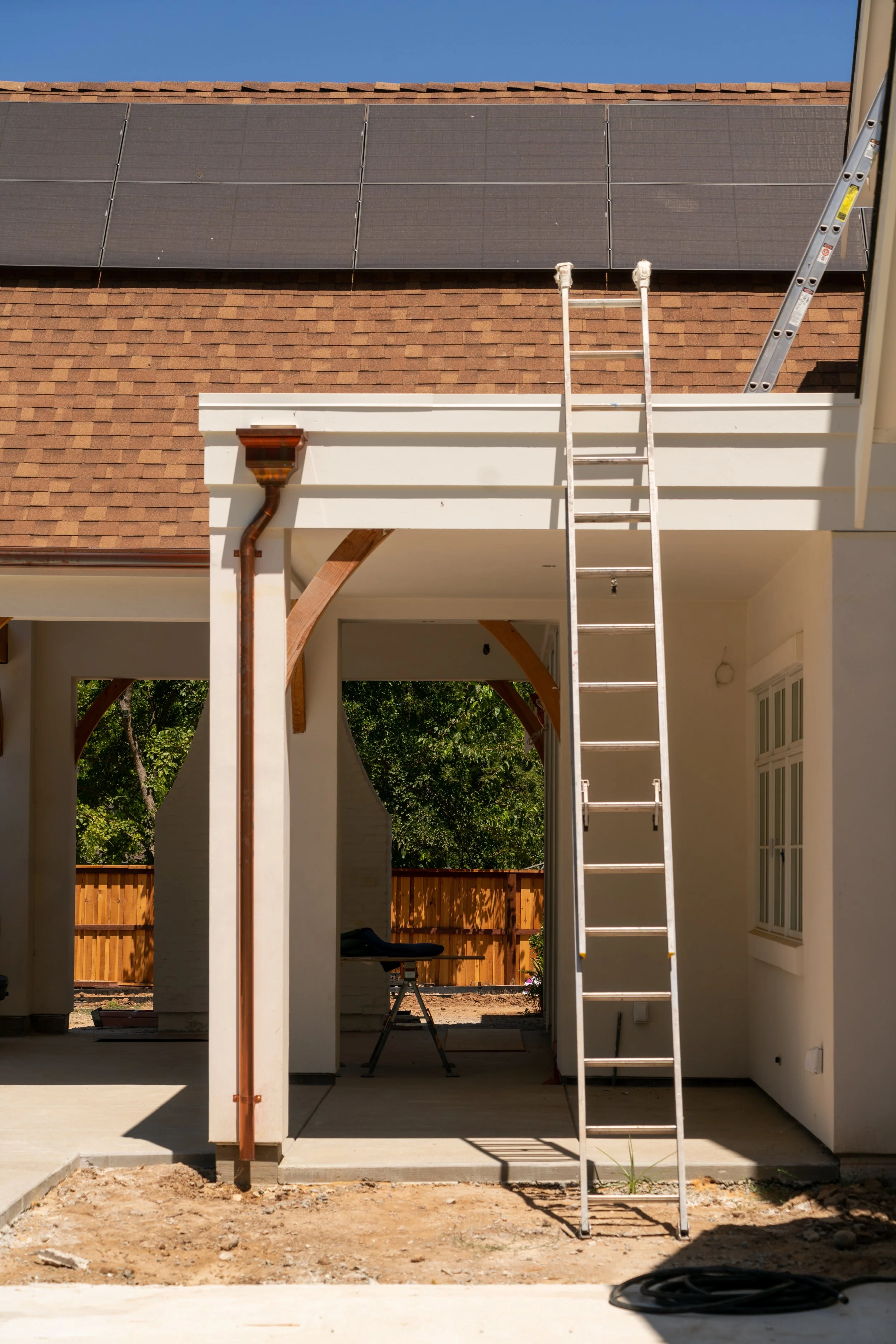 A ladder leans against the patio roof of a Granite Bay custom home