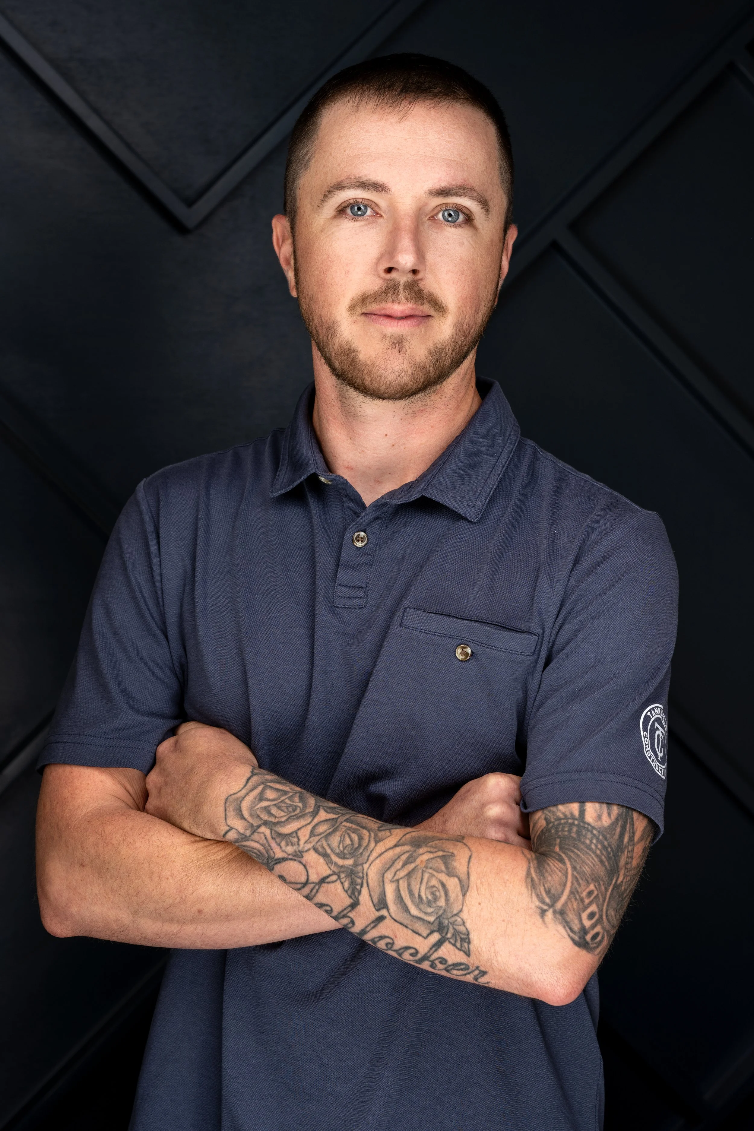 A smiling Tankersley Build Co Employee headshot. He is standing against a dark, textured background.