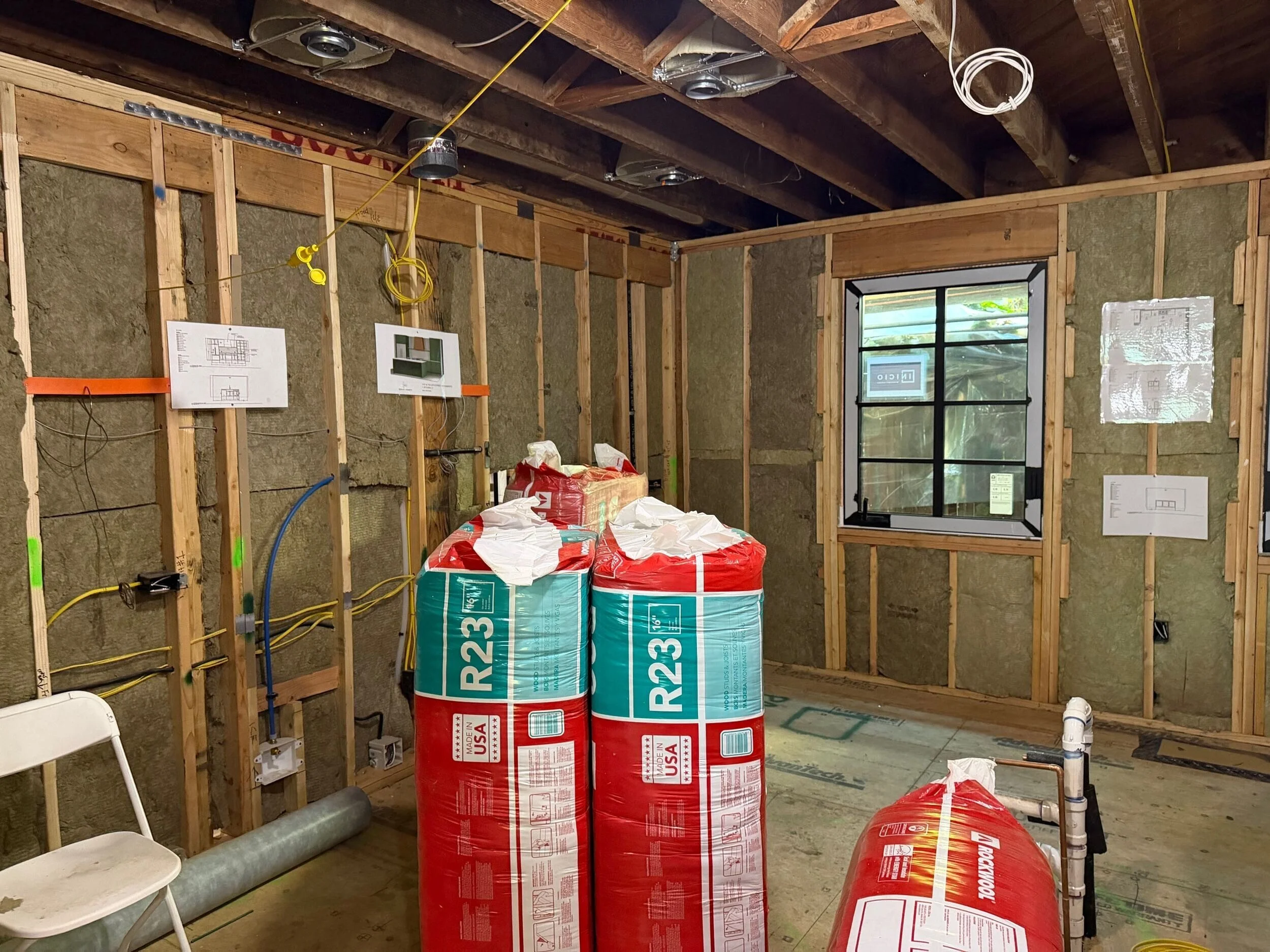 Bags of Rockwool insulation sit inside a custom home ready to be installed