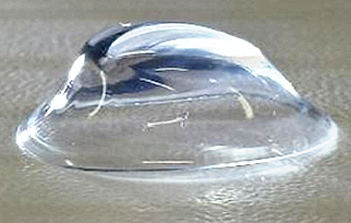 Close-up of a transparent water droplet on a surface.
