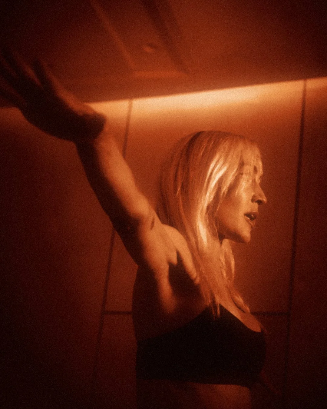 Full Body Burn: arms flung wide, eyes forward, glowing in amber light