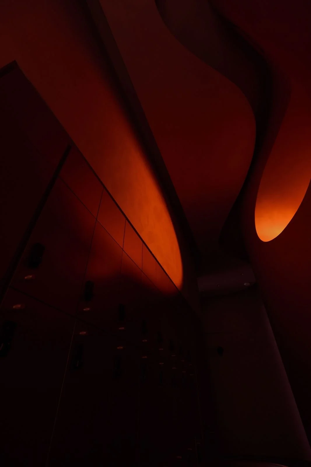 Curved wall sconces glowing amber in the dark