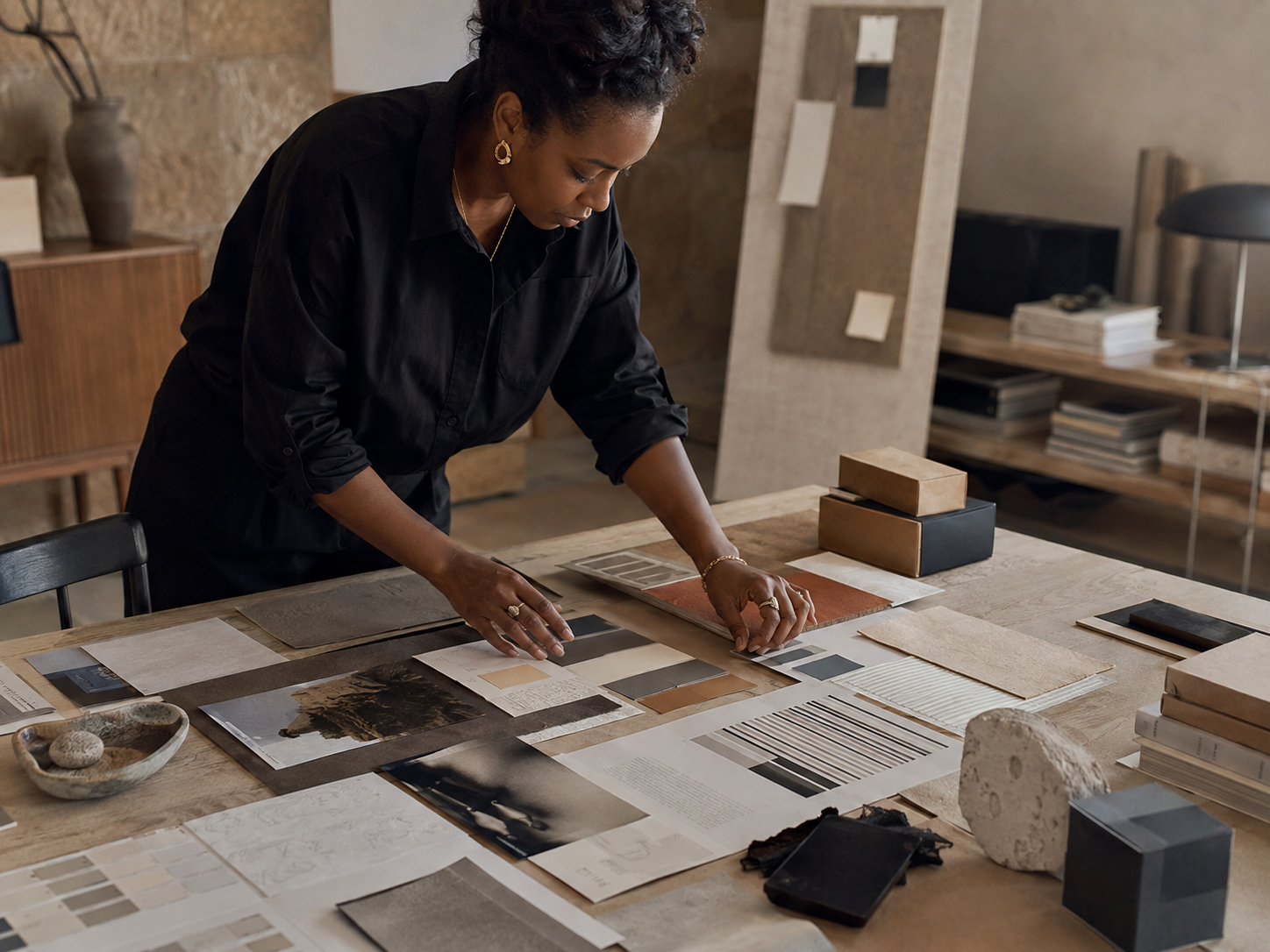 Brand strategist arranging color, material, and identity-system components in a design studio