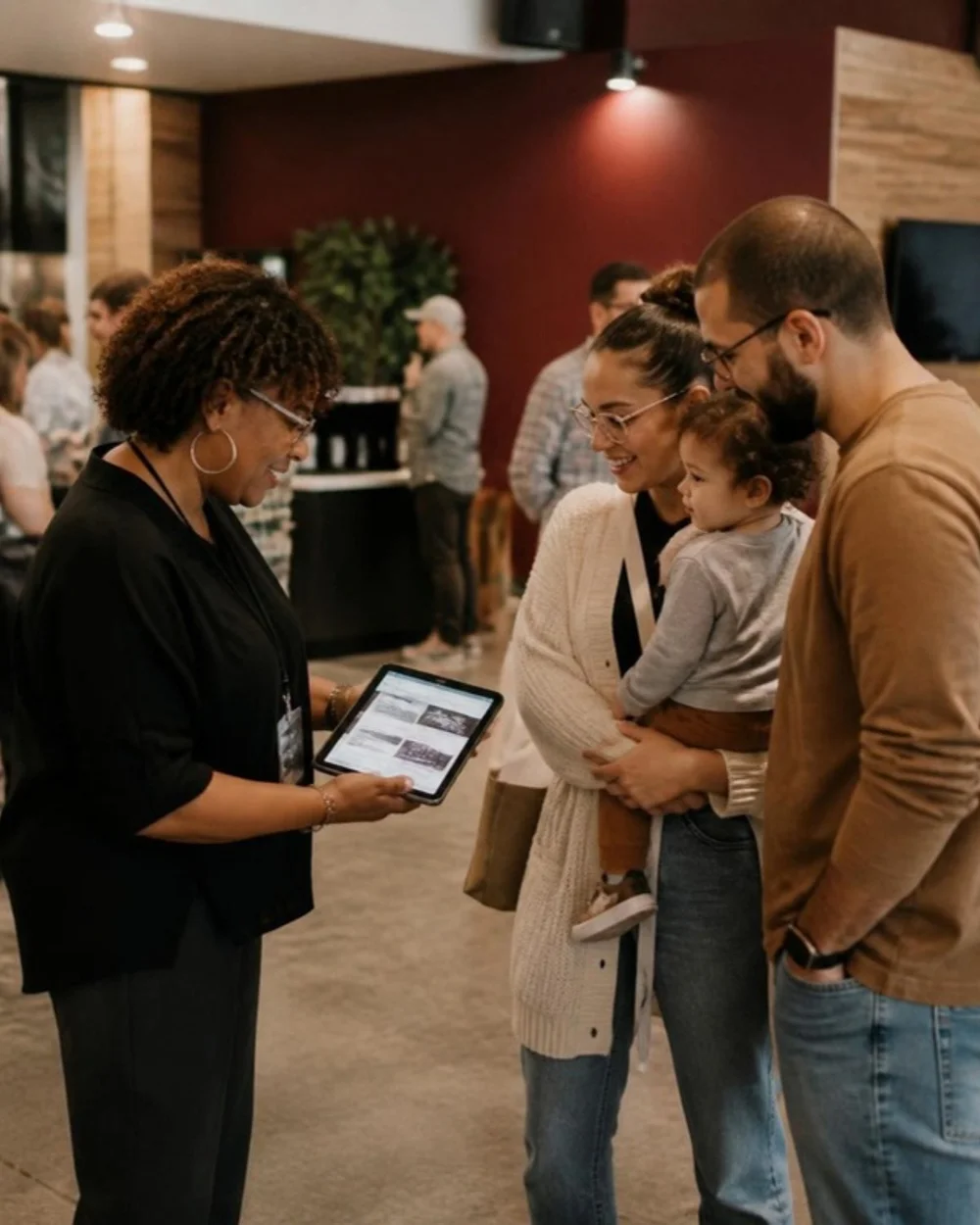 Church greeter showing a first time visitor family the church website on a tablet