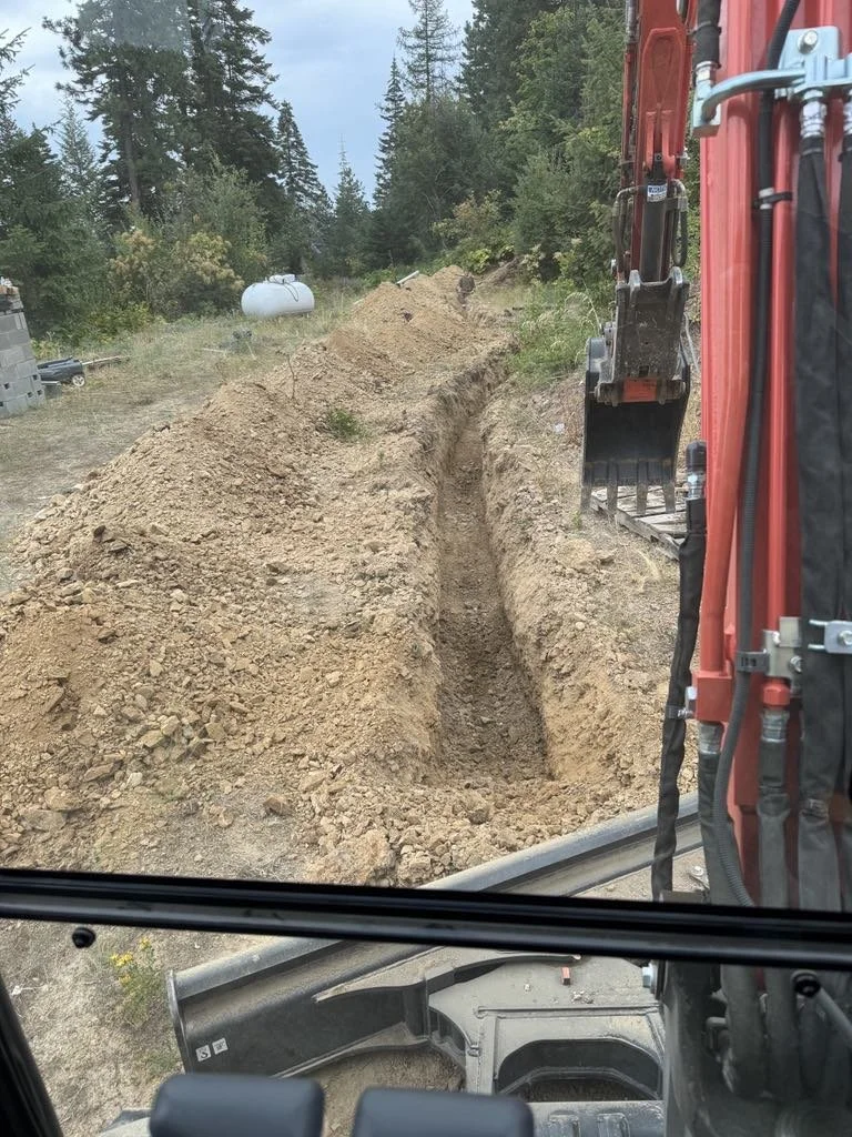 Close-up of an excavator bucket digging into dirt at a construction site.