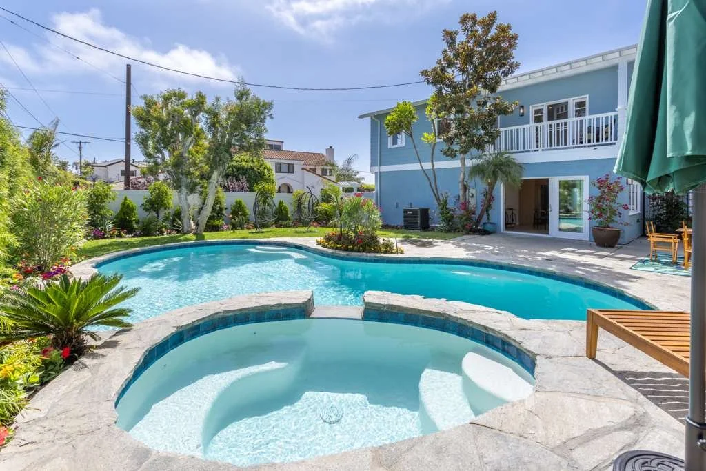 Rebuilt pool and spa with clear water and surrounding landscaping after restoration