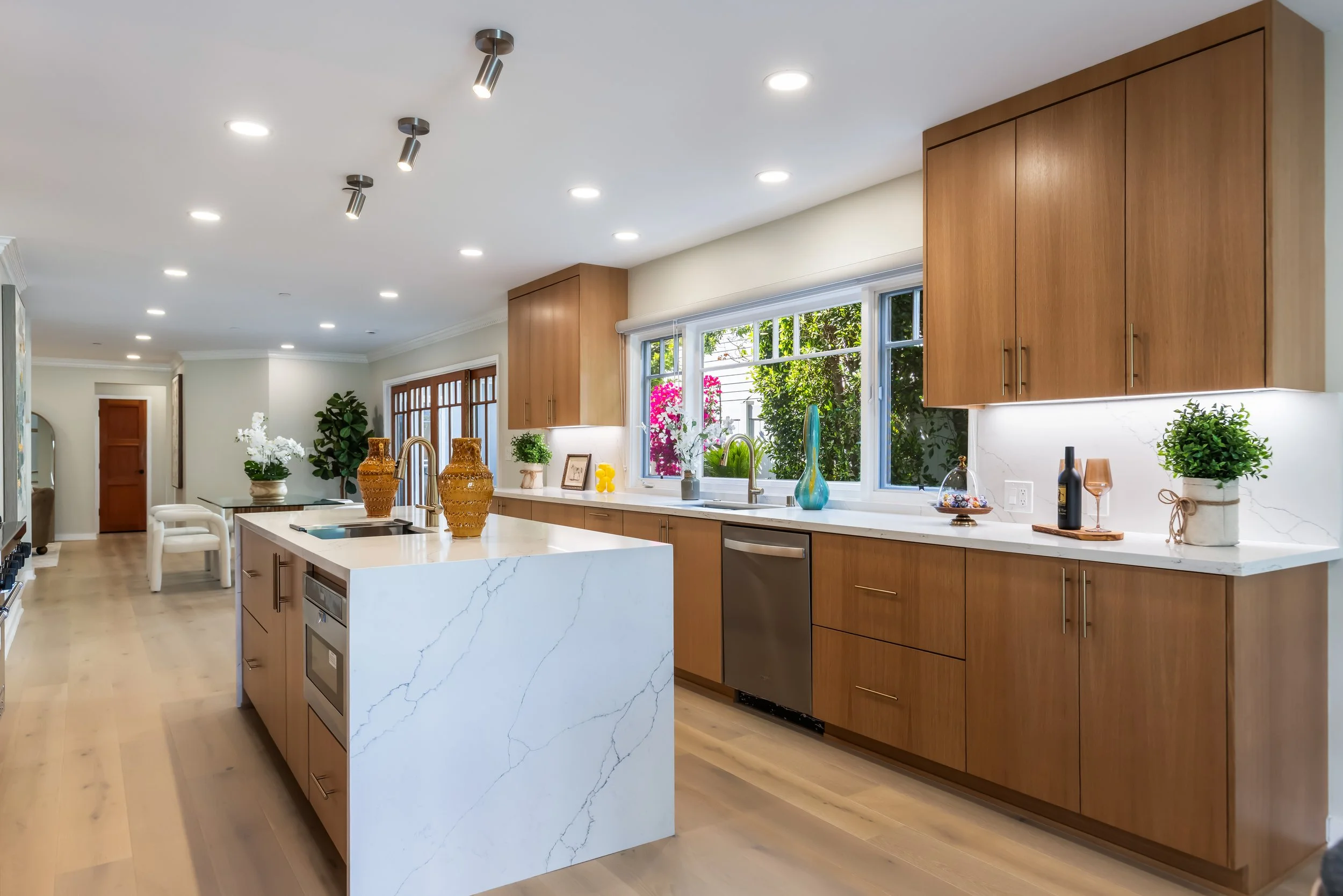 Modern kitchen remodel with wood cabinetry, large island, and updated lighting