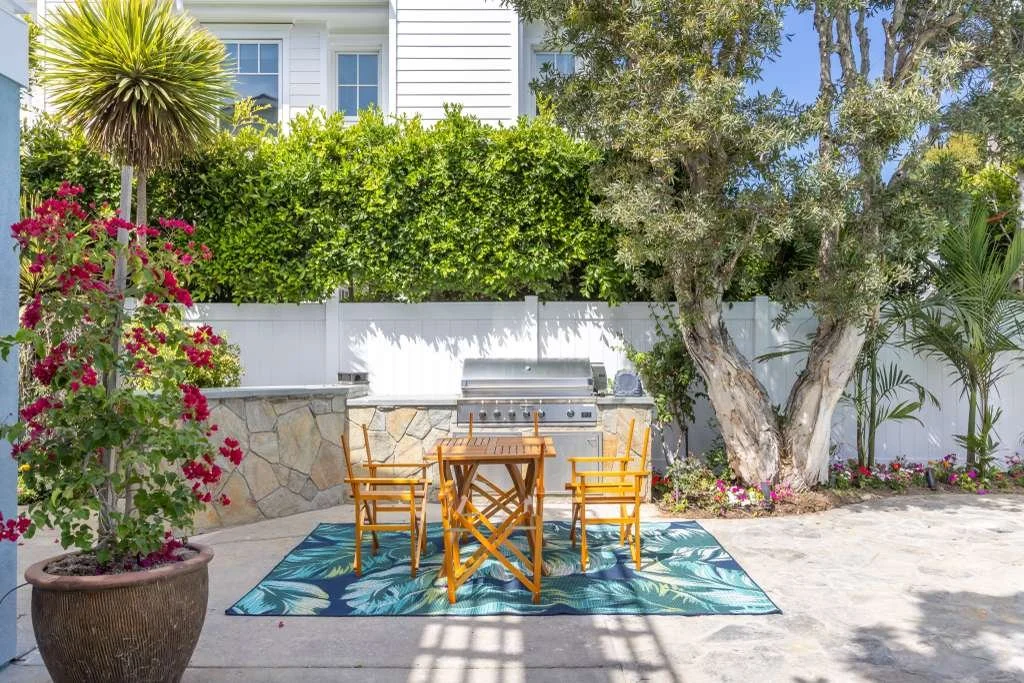 Outdoor patio dining area with table, plants, and stonework after backyard restoration