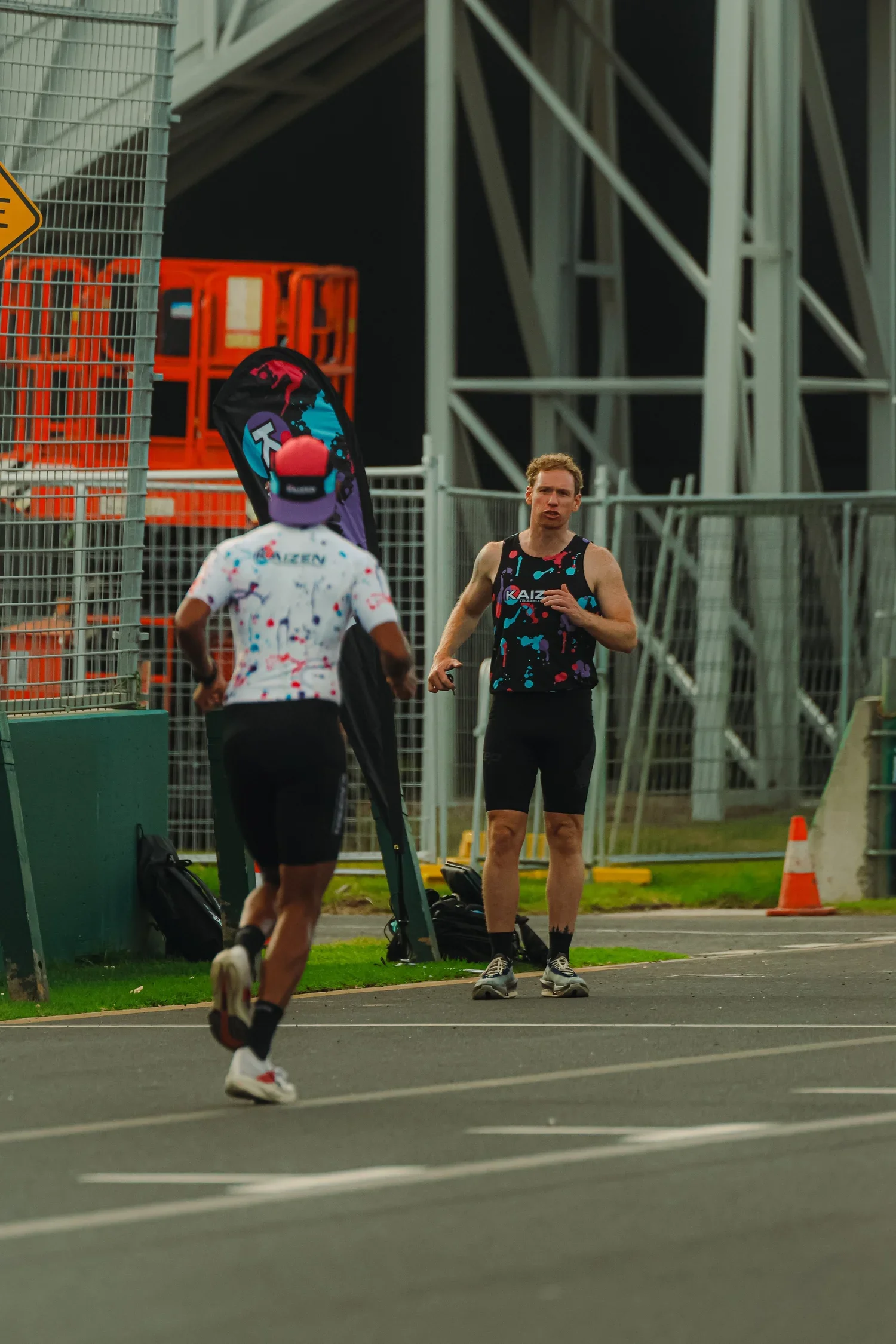 Two runners approaching a race finish line at an outdoor track.