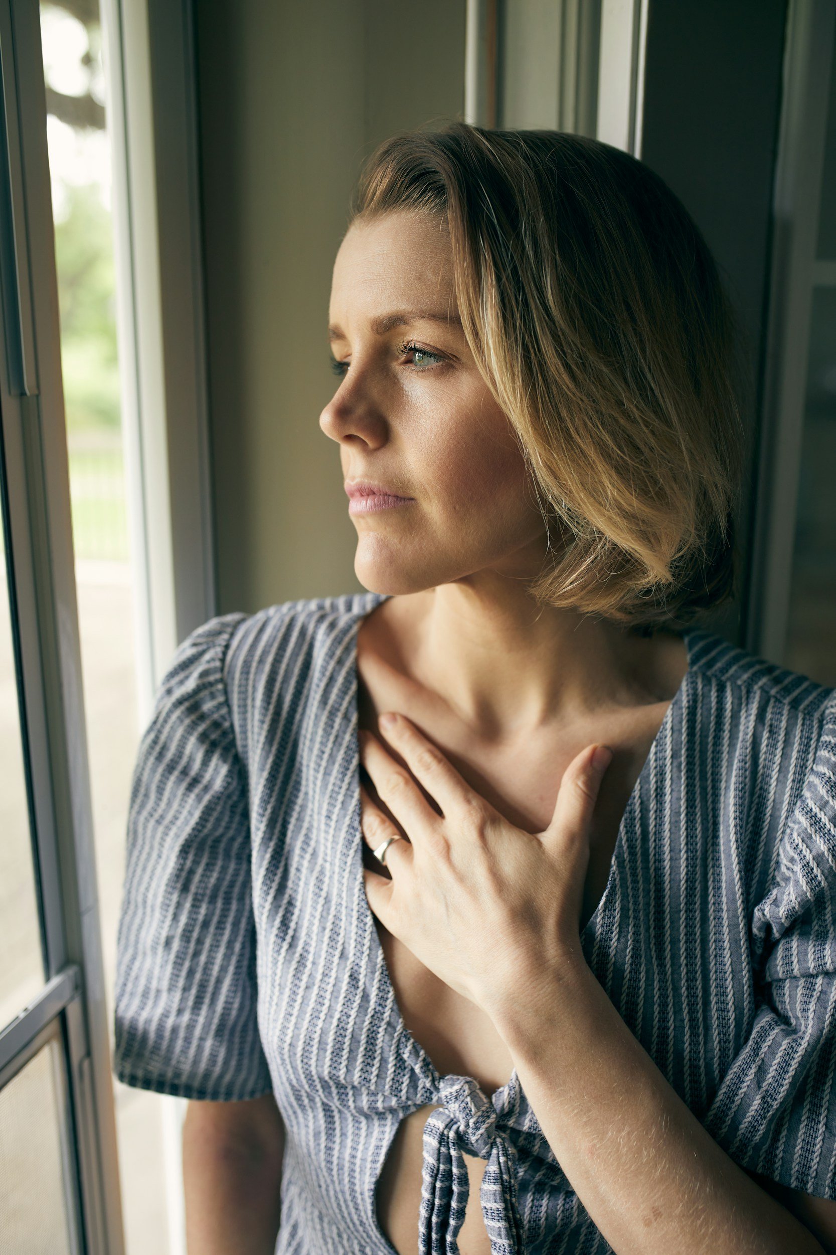 Woman reconnecting with her body through a gentle somatic therapy practice in a peaceful home environment