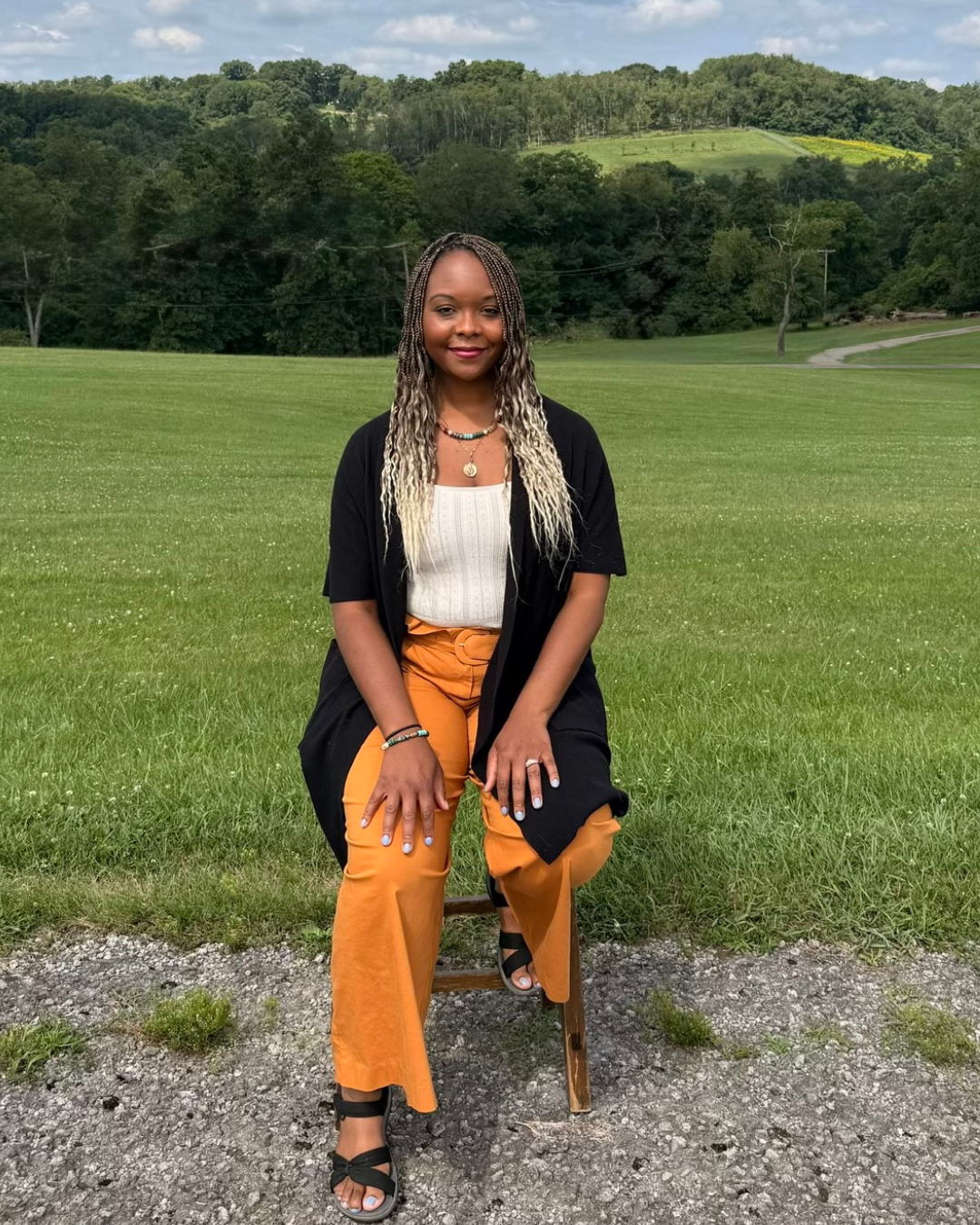 Brittany Steiner, LPC, sitting peacefully on a park bench surrounded by nature, reflecting the calm and grounded approach of somatic therapy.