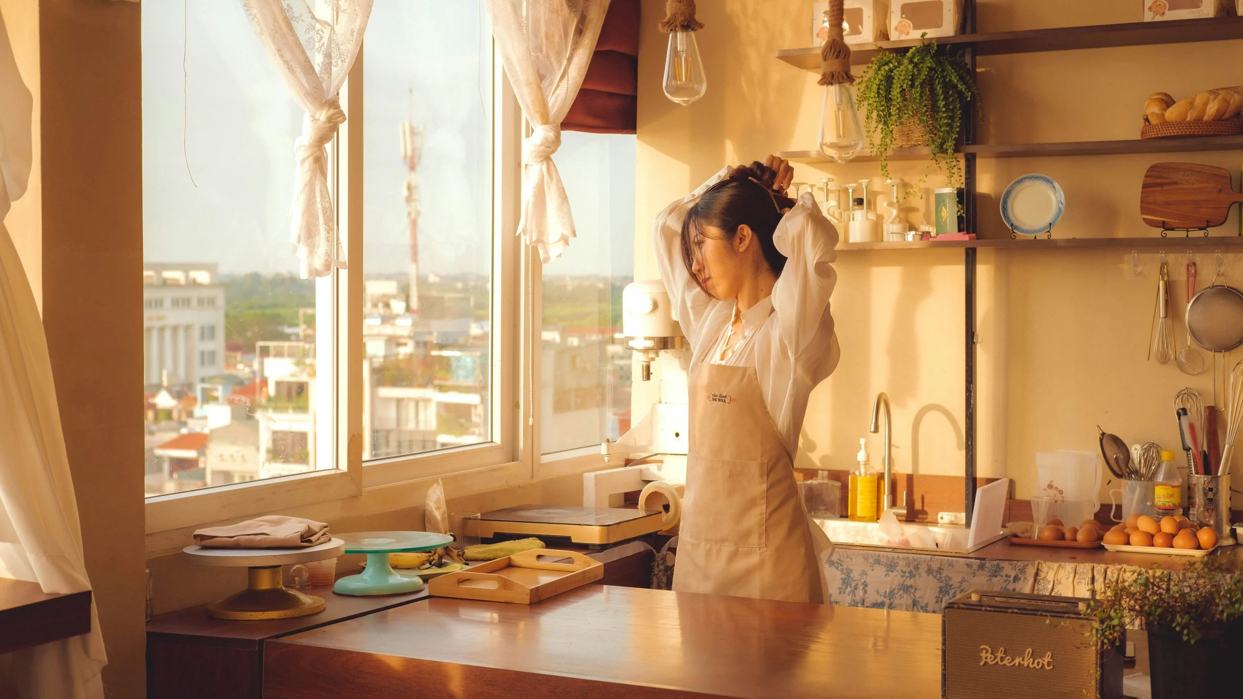 Woman preparing food in a sunlit home kitchen representing practical nutrition strategies for midlife metabolism and menopause.
