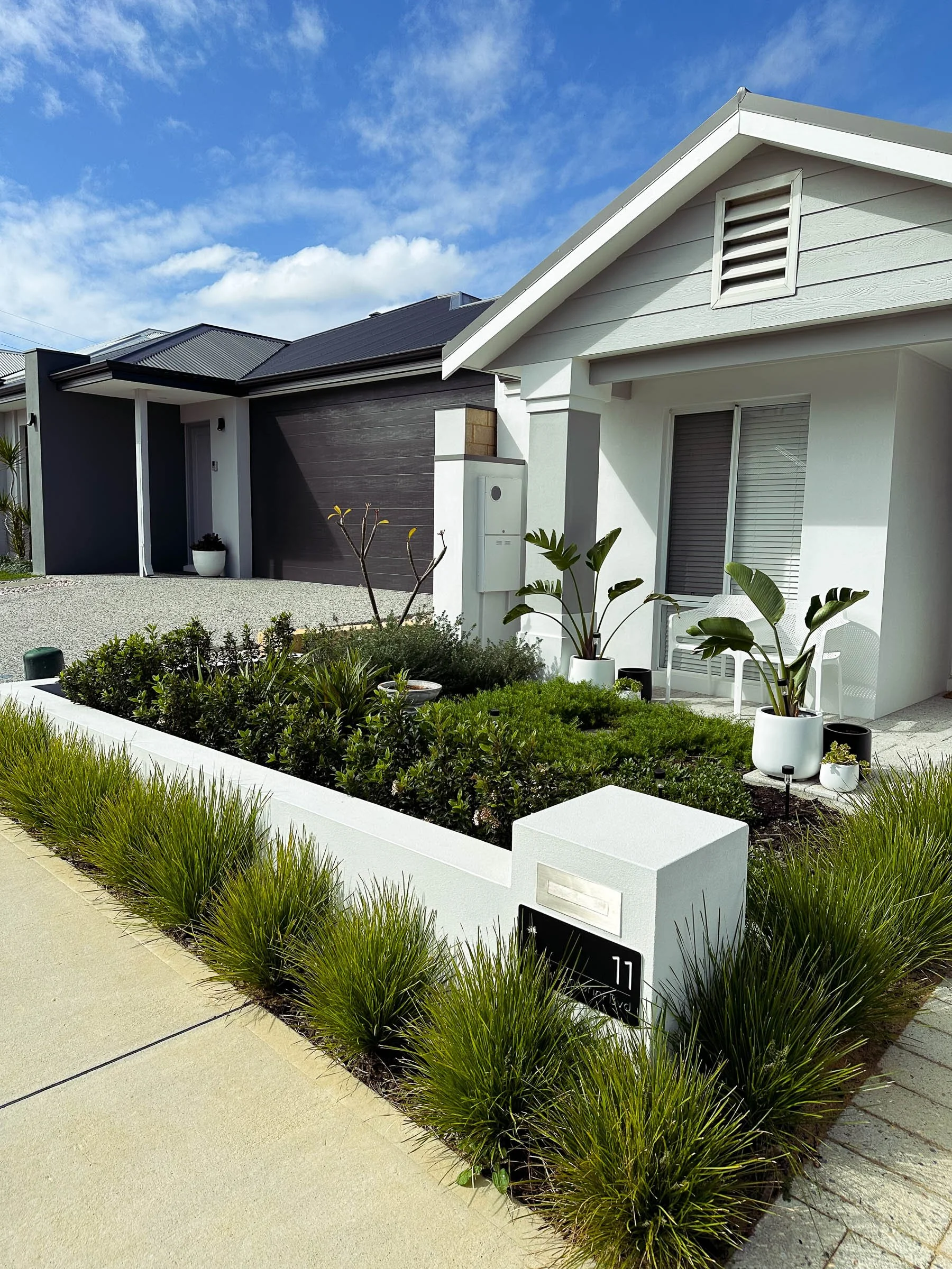 A Coogee garden designed for low maintenance with structured planting, Magnolia trees, bluestone steppers, and neat lawn edging.