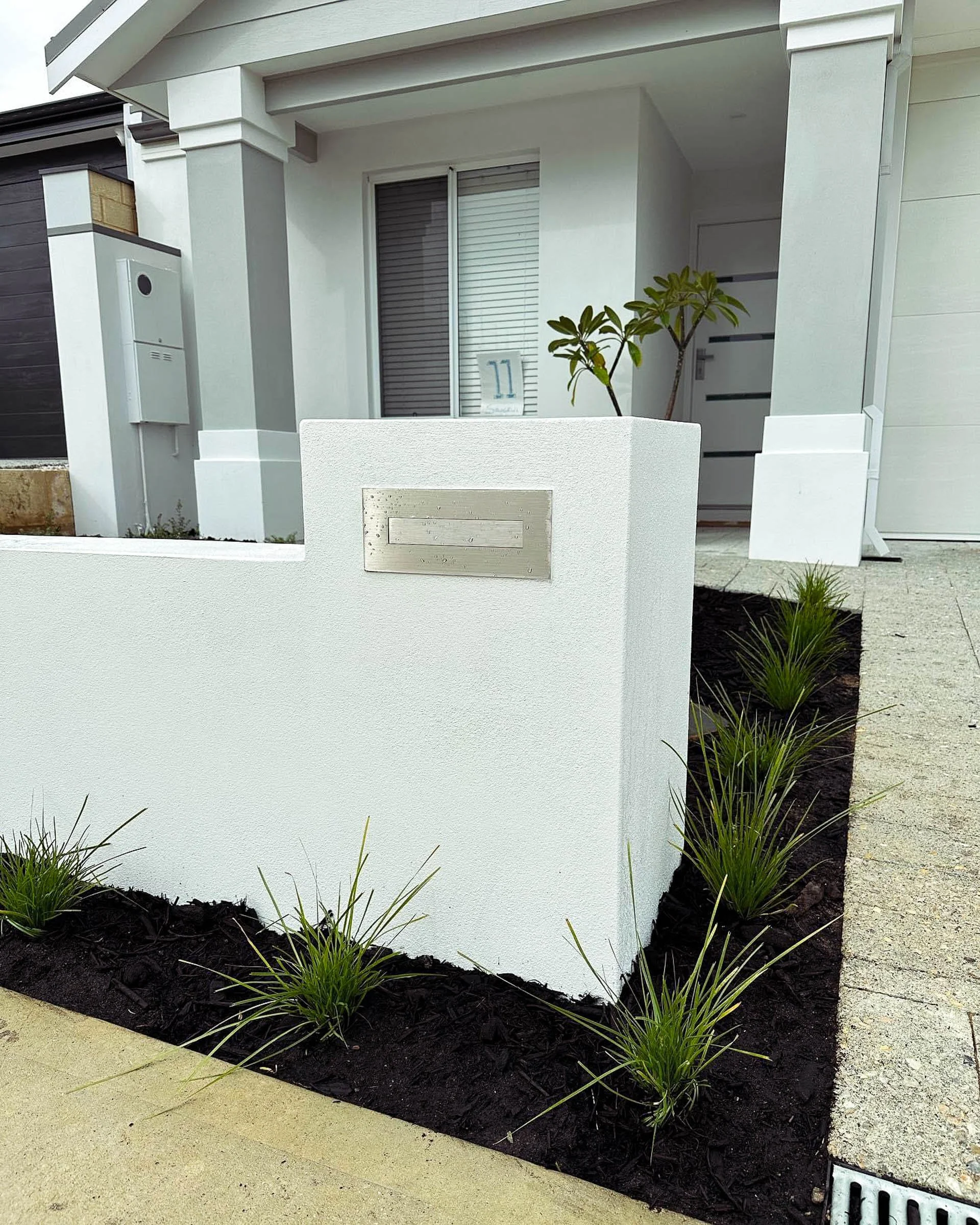 A Coogee garden designed for low maintenance with structured planting, Magnolia trees, bluestone steppers, and neat lawn edging.