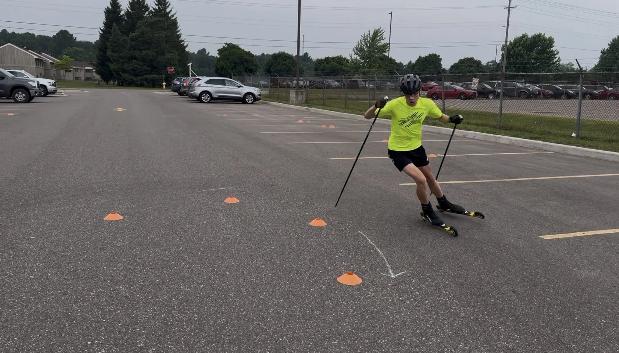 Roller-skier goes around cones in a parking lot