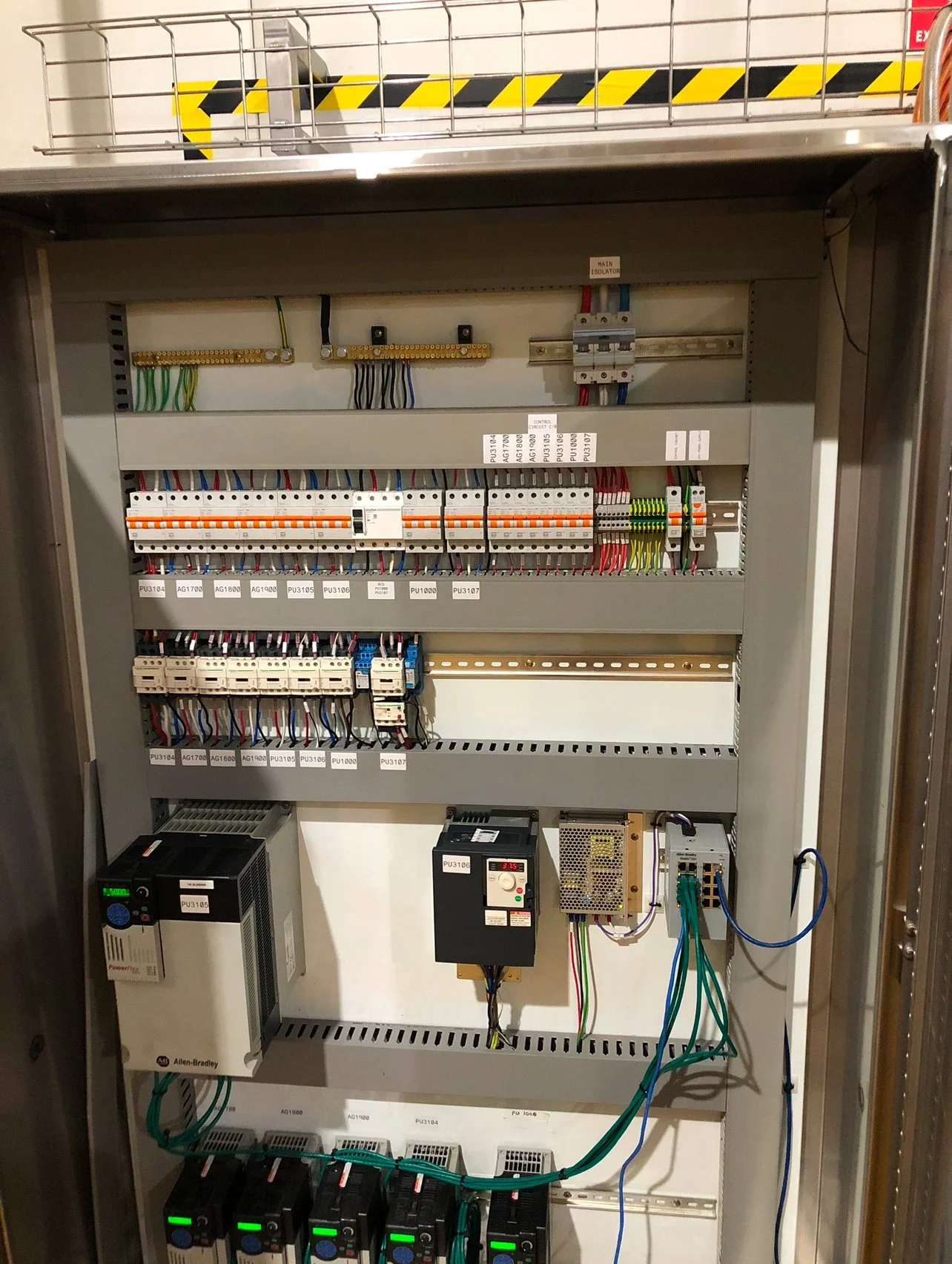 An electrical control panel with various circuit breakers, wiring, and electronic components inside a metal enclosure.