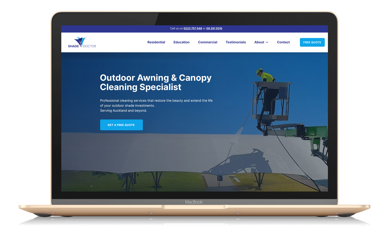 Laptop displaying a website for Shade Doctor, a company specializing in outdoor awning and canopy cleaning. The homepage features a large image of a worker in a lift cleaning an outdoor canopy, with navigation menu items including Residential, Education, Commercial, Testimonials, About, and Contact. There's also a prominent 'Get a Free Quote' button.