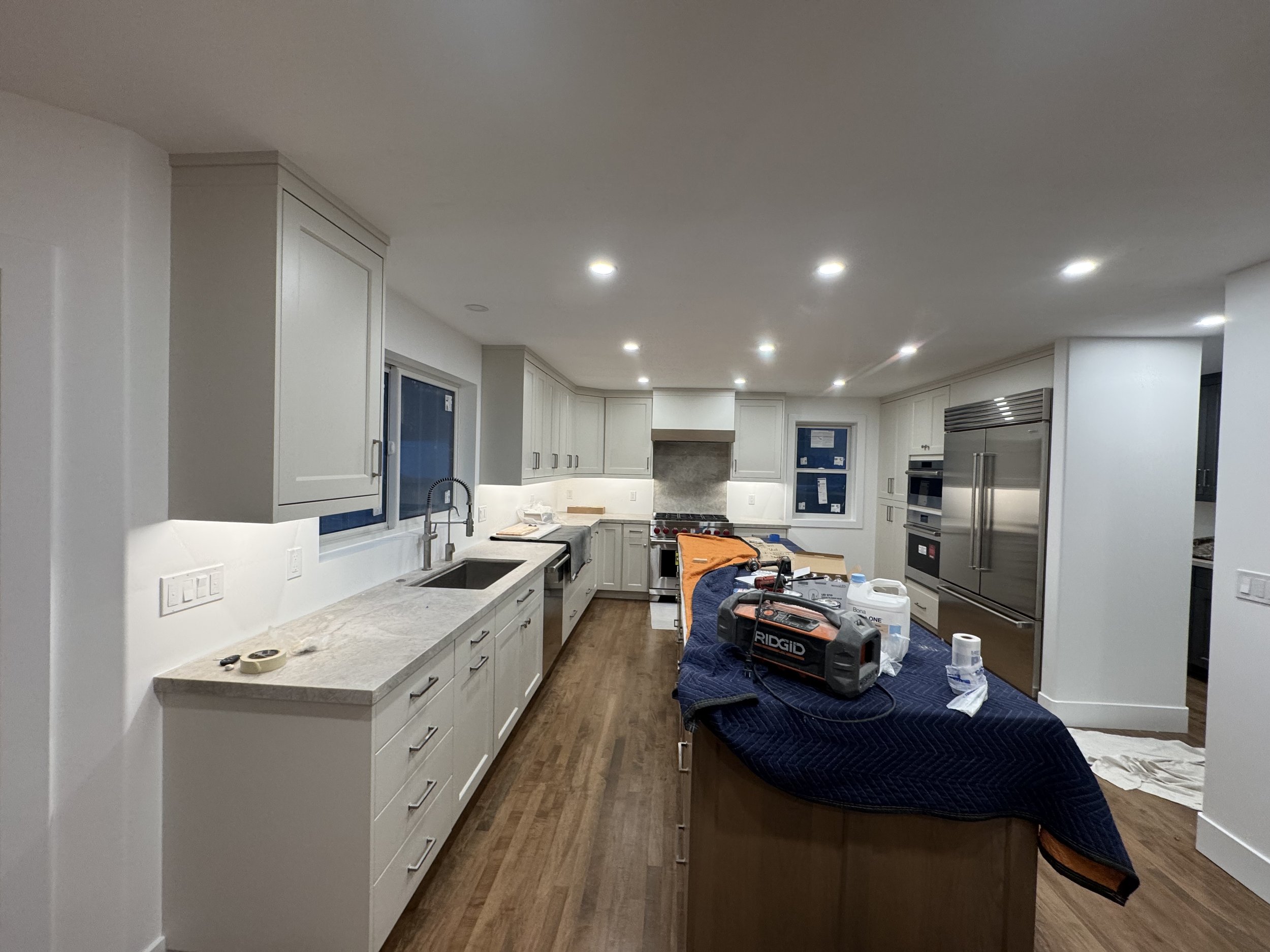 Modern kitchen with white cabinets, stainless steel appliances, and an island.