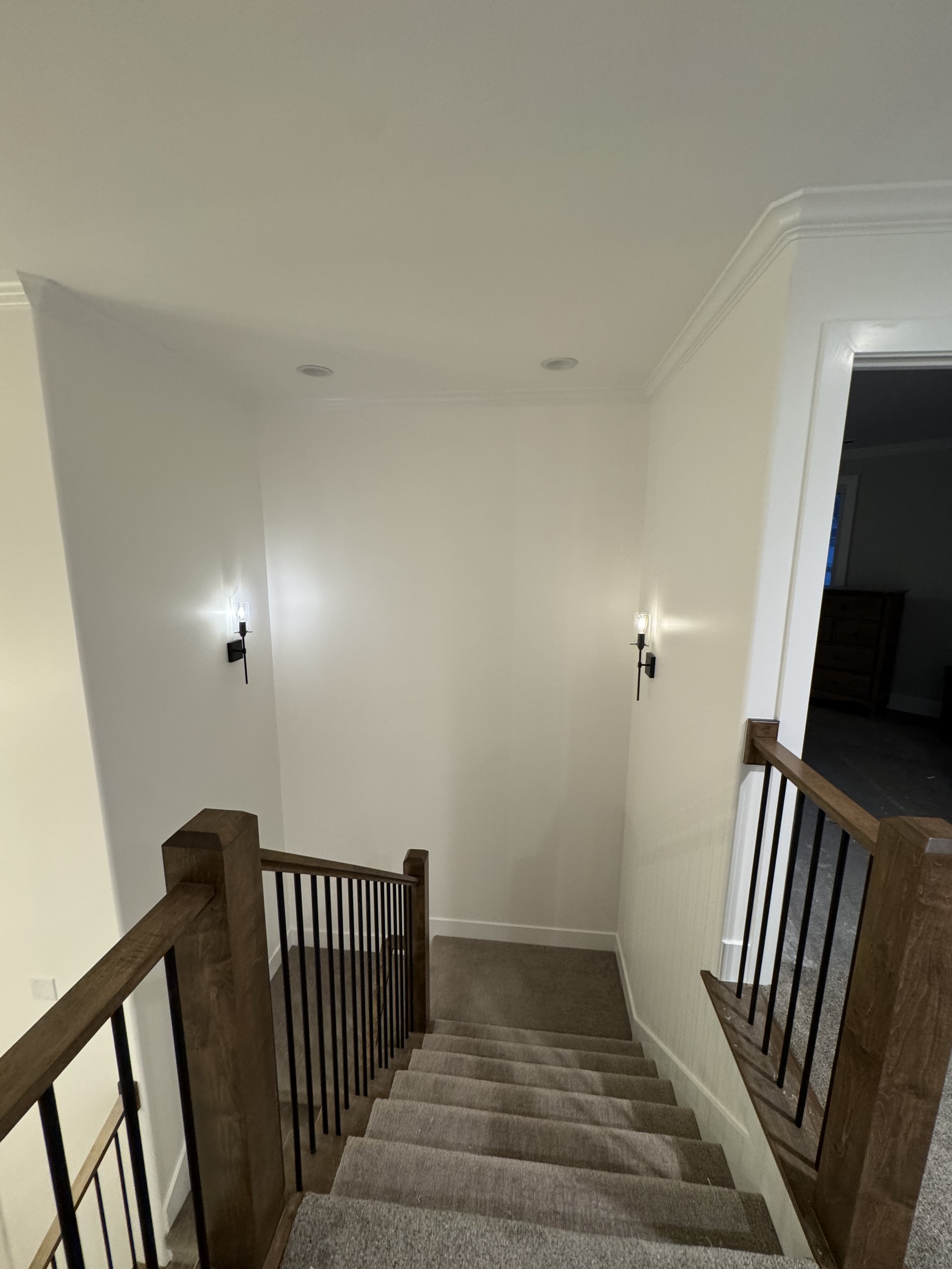  wall-mounted lights leading to a lower level in a house.