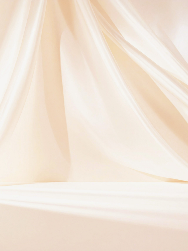 Cream-colored satin fabric draped softly with gentle folds and sheen.