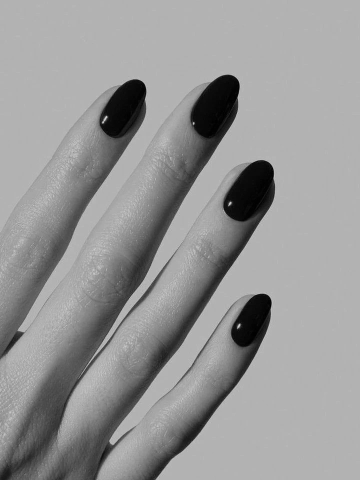 Close-up of a hand with neatly manicured nails painted black.