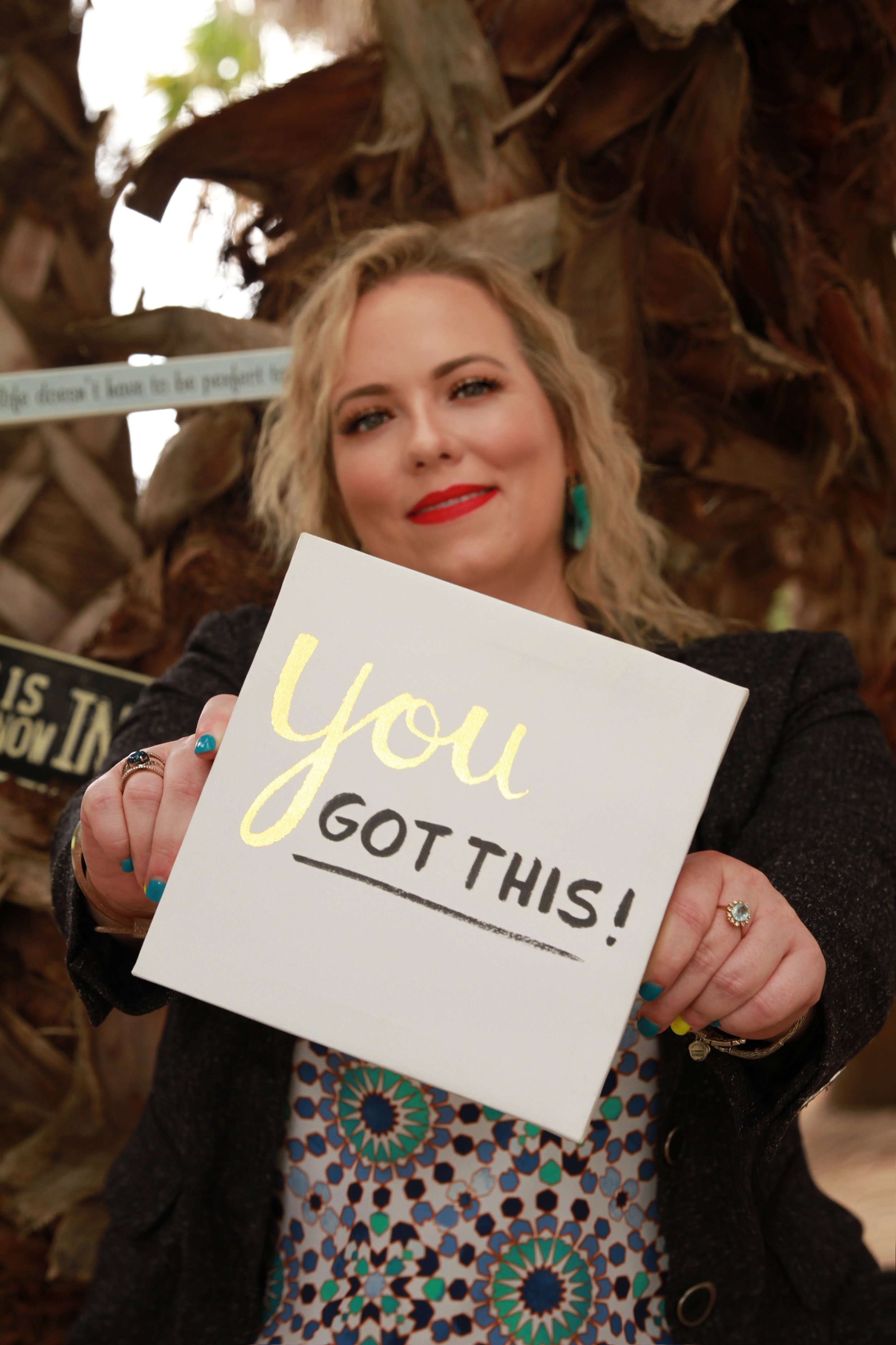 Dr. Nichole Vincent holding a “You Got This” sign as encouragement for adults seeking therapy support.