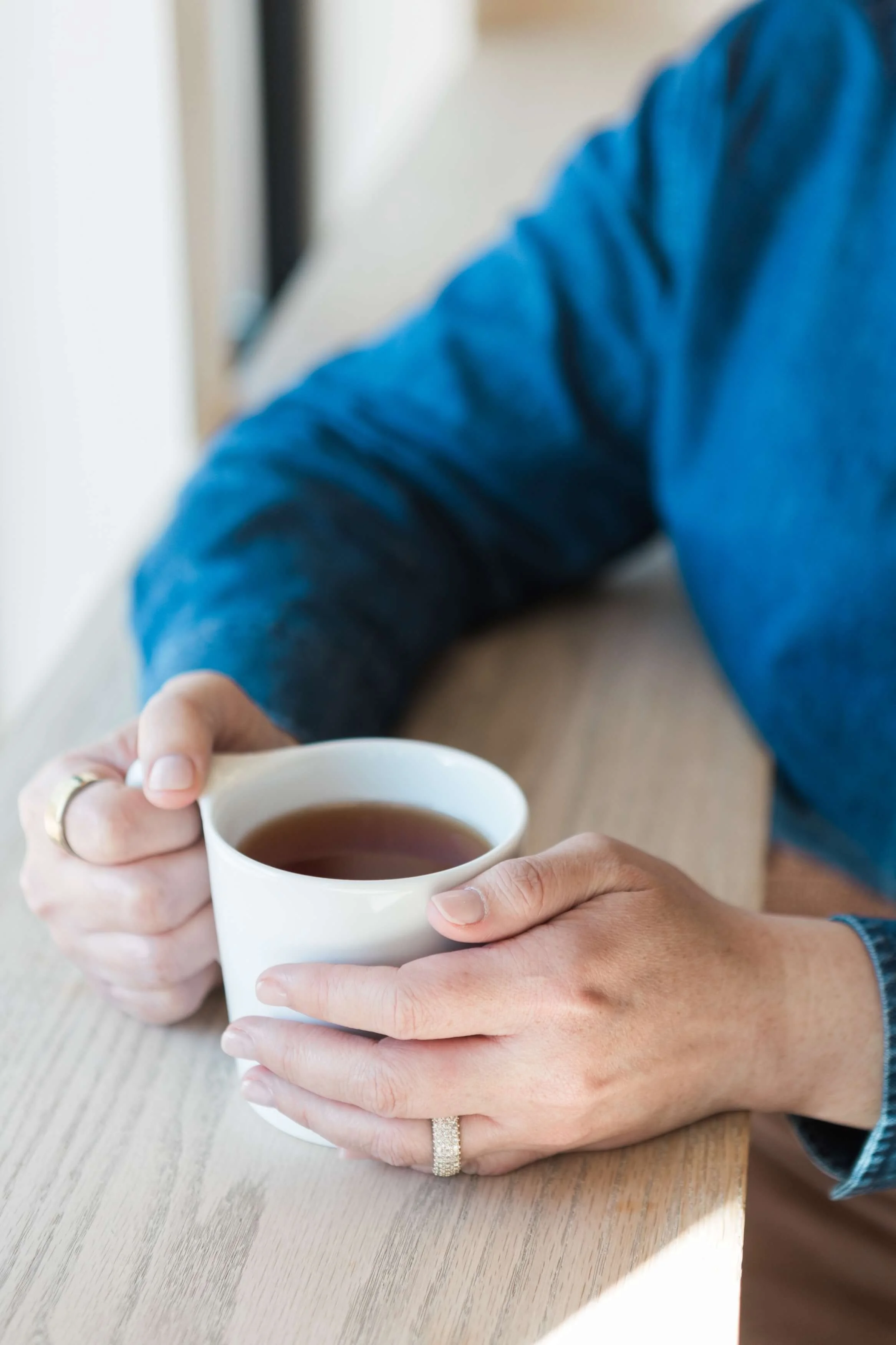 Client holding a warm drink during a quiet moment of reflection