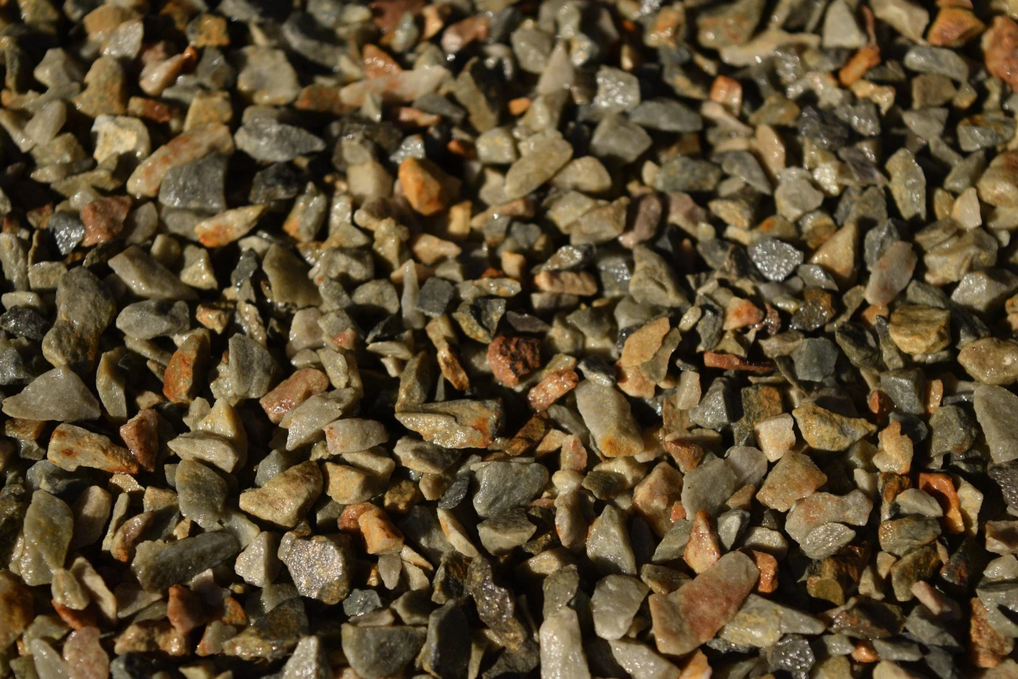 Close-up of small, multicolored gravel stones on the ground.