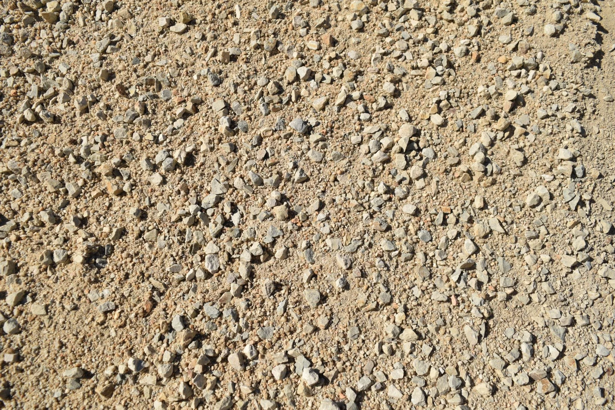 Close-up view of a surface covered with small gravel and sand particles.