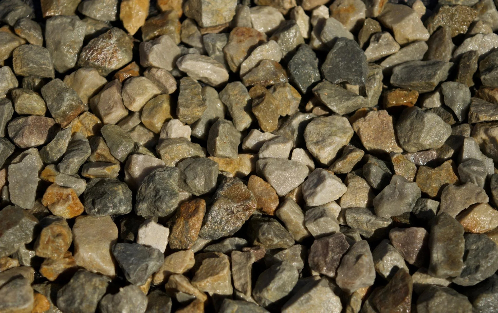Close-up of small, angular rocks in shades of gray, brown, and beige.