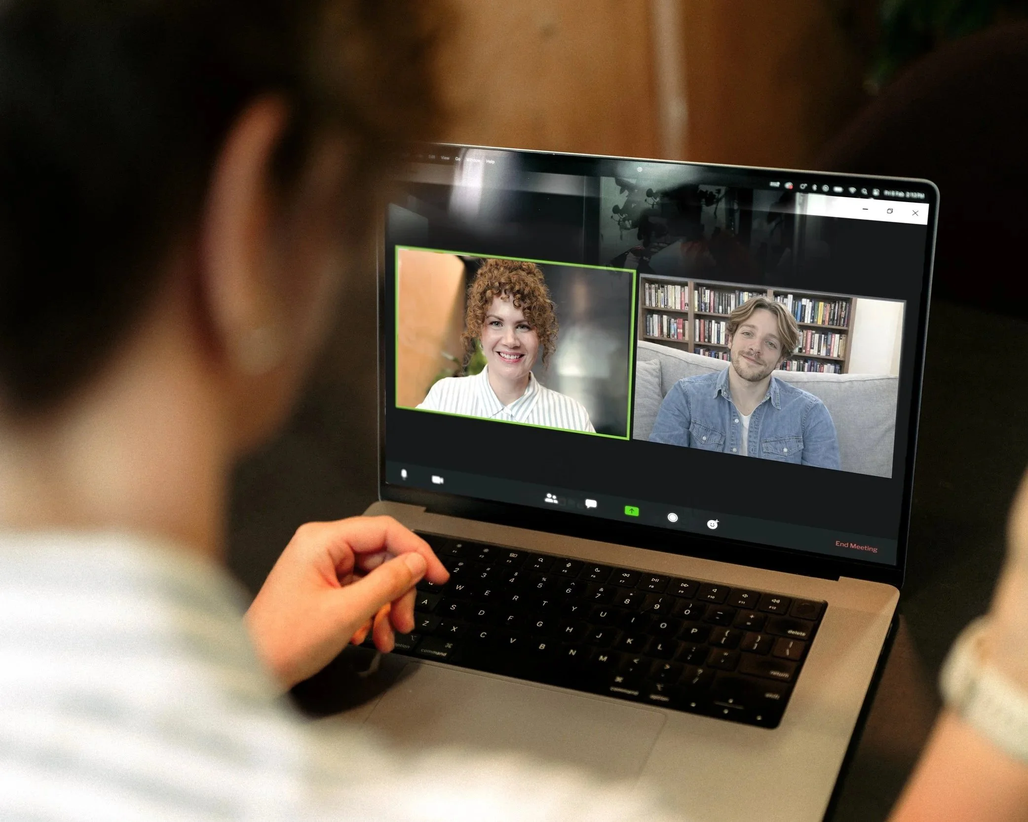 Close-up of a laptop screen showing a video call with two participants in a split-screen view.
