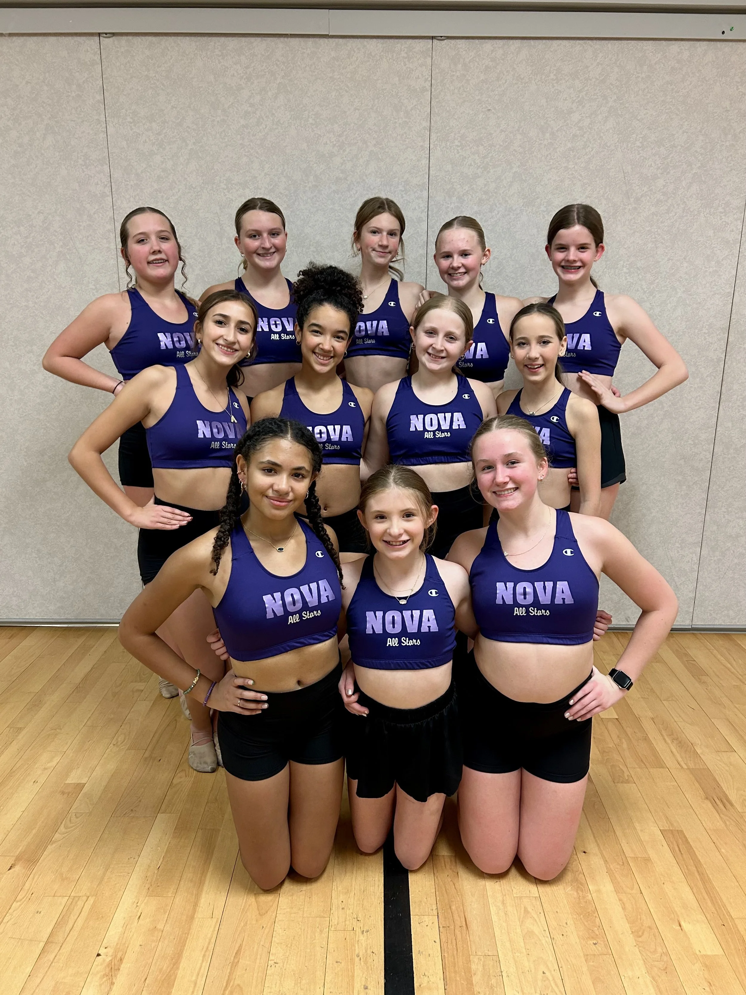 A girls' cheerleading team in blue crop tops with