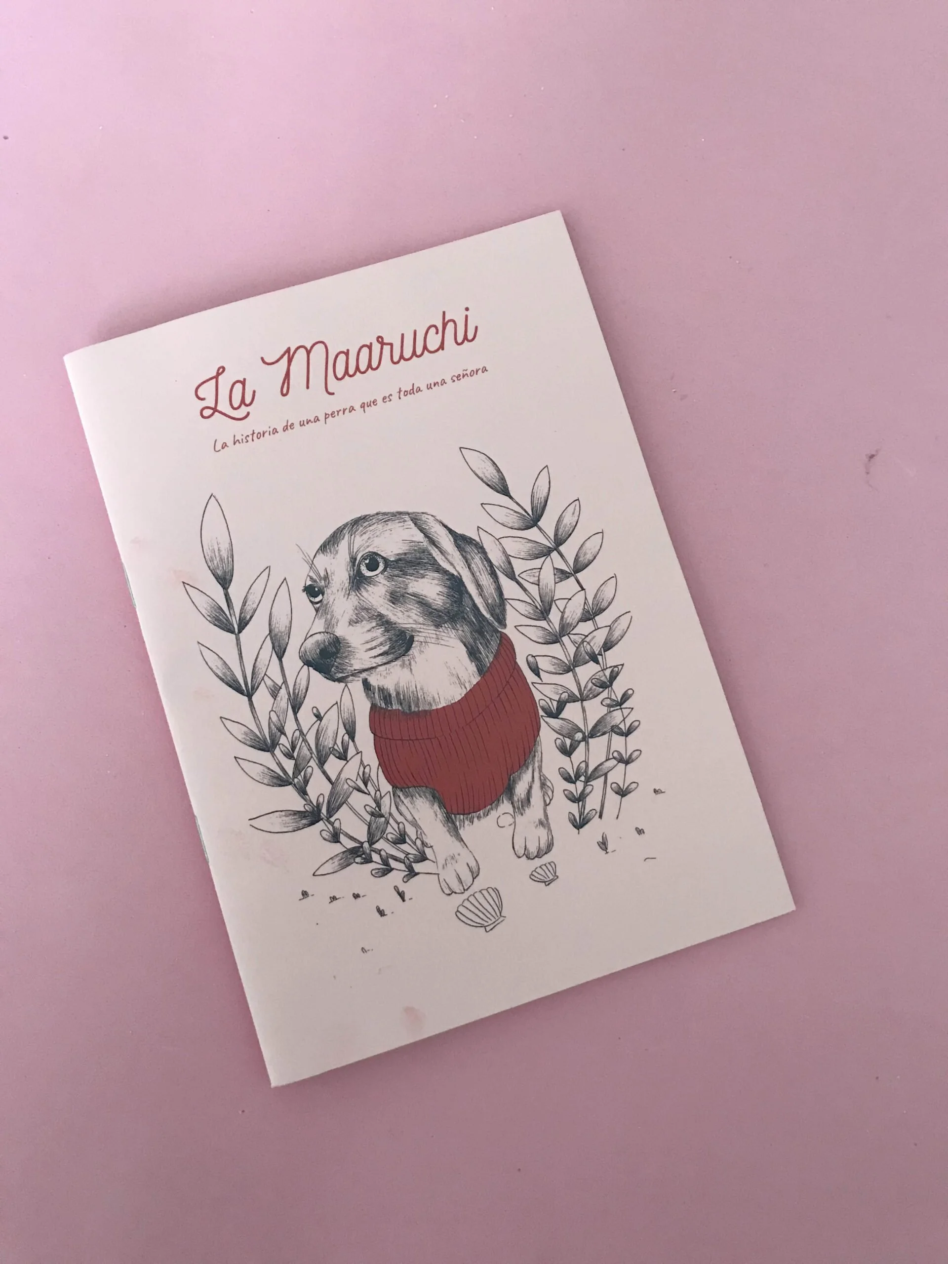 Portada de una historia titulada "La Maaruuchi" con la imagen de un perro con suéter rojo rodeado de hojas.