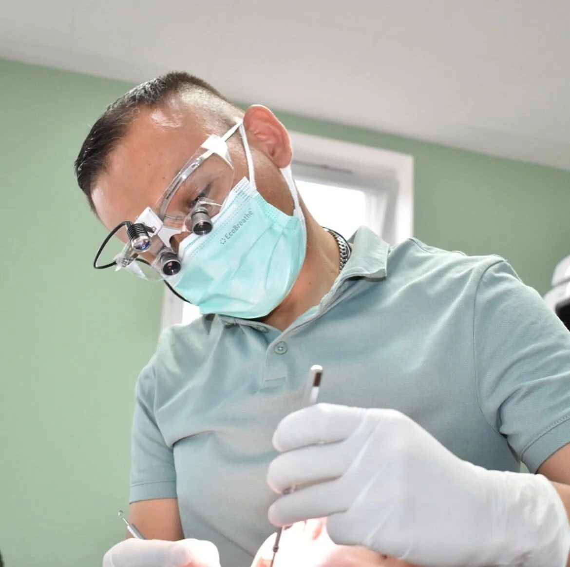 Dentista sonriente con instrumentos en una clínica dental moderna.