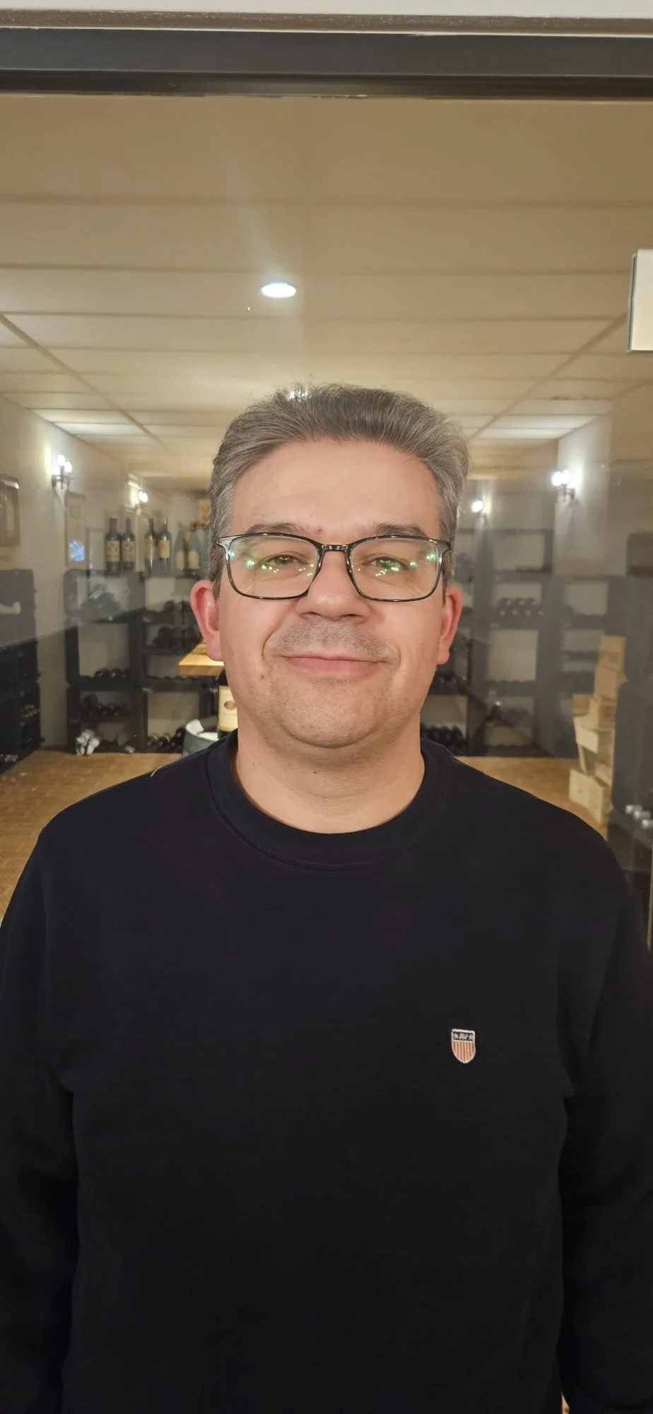 Joven mujer sonriendo con chaqueta vino y pantalones de cuero en un fondo blanco.