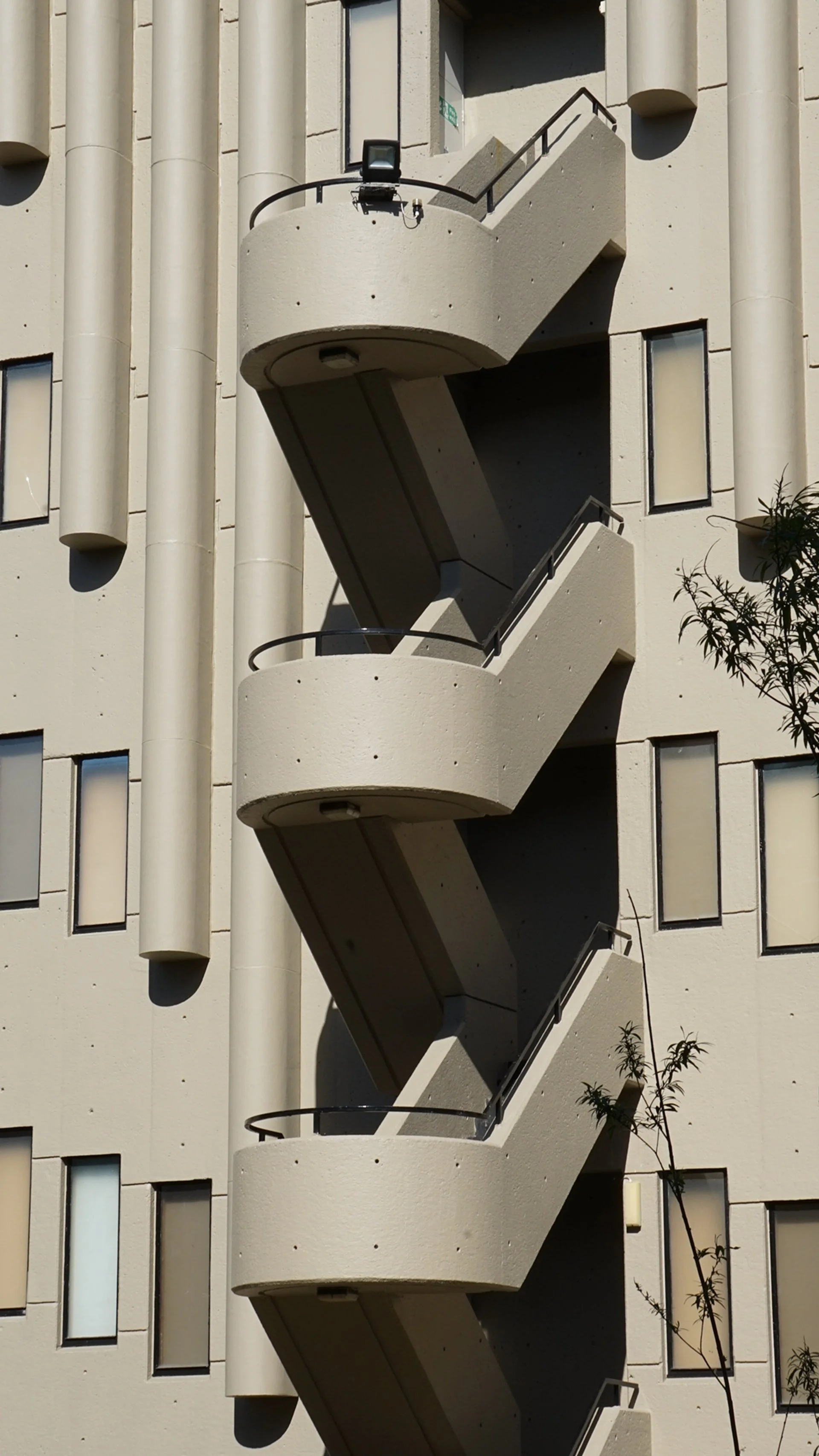 Exterior view of a building with a vertical fire escape staircase.