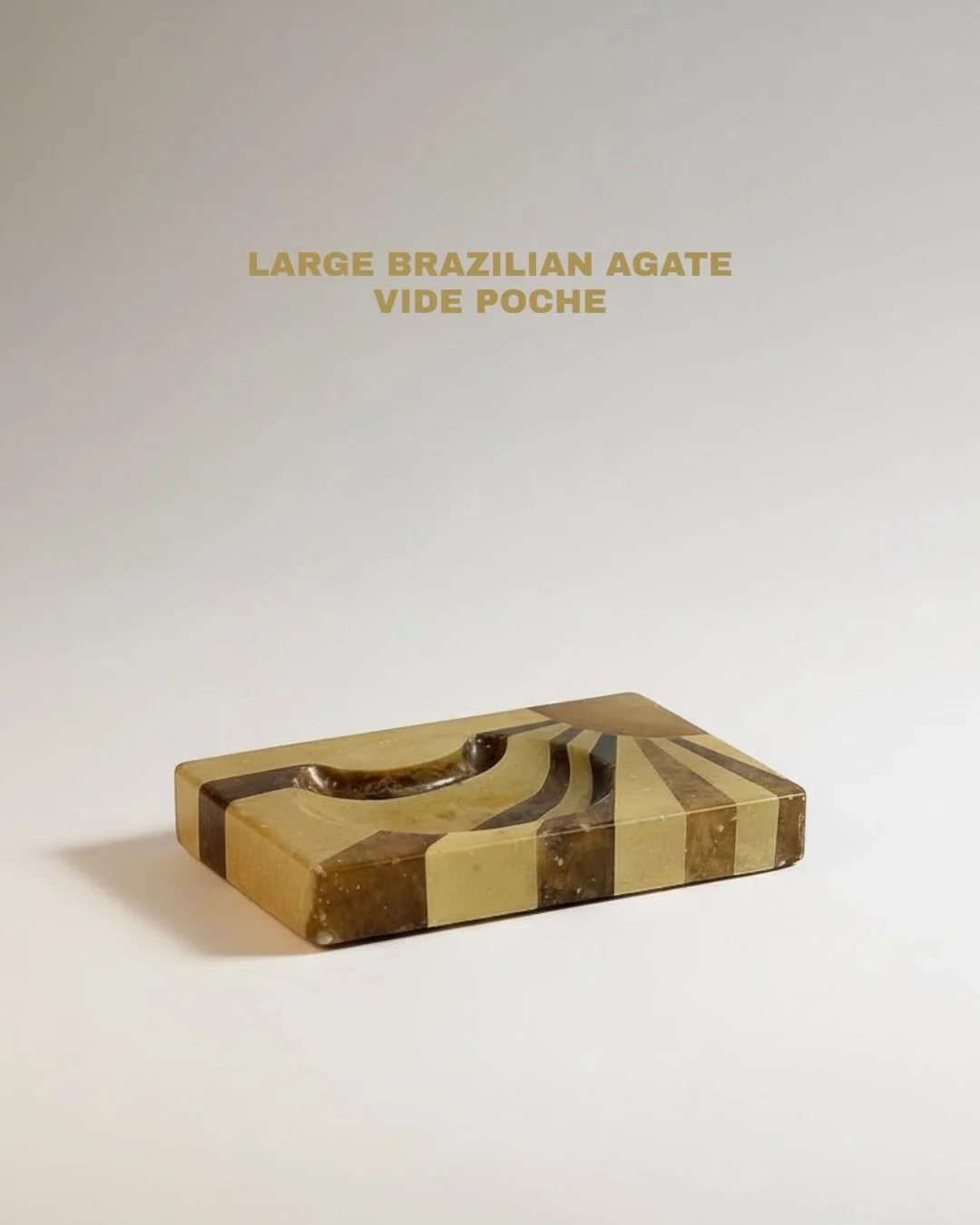 Carved from a thick slice of natural banded agate, cut from a Brazilian geode.   The interior surface is polished, while the outer edge remains in its natural, unworked state.
The agate shows banding in grey, brown, and translucent honey tones.   Pro