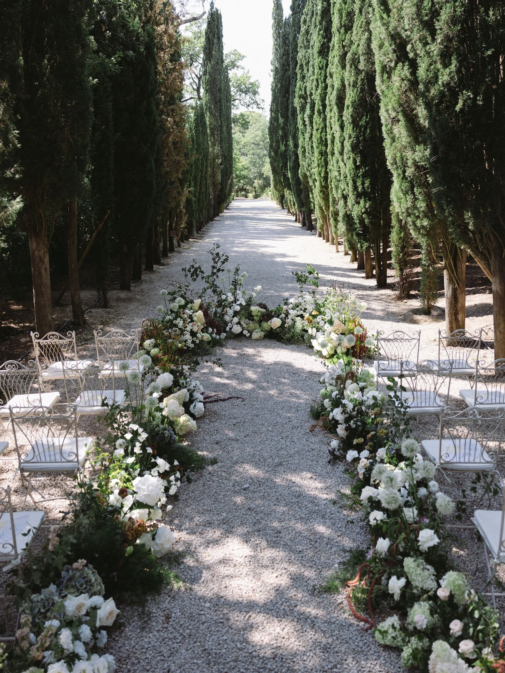 When the venue is already this beautiful, let the flowers follow its lines 🌿🤍

An alley of cypress trees, white gravel and dappled summer light. This ceremony didn&rsquo;t need an arch or a backdrop: the trees were already the cathedral. So instead