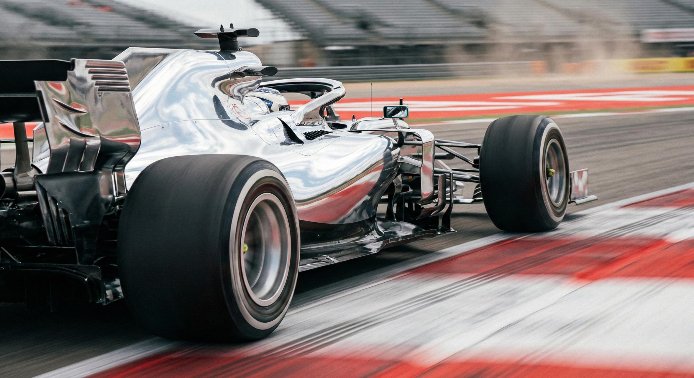 Monoplace de Formule 1 argentée lancée à pleine vitesse sur la piste, effet de mouvement