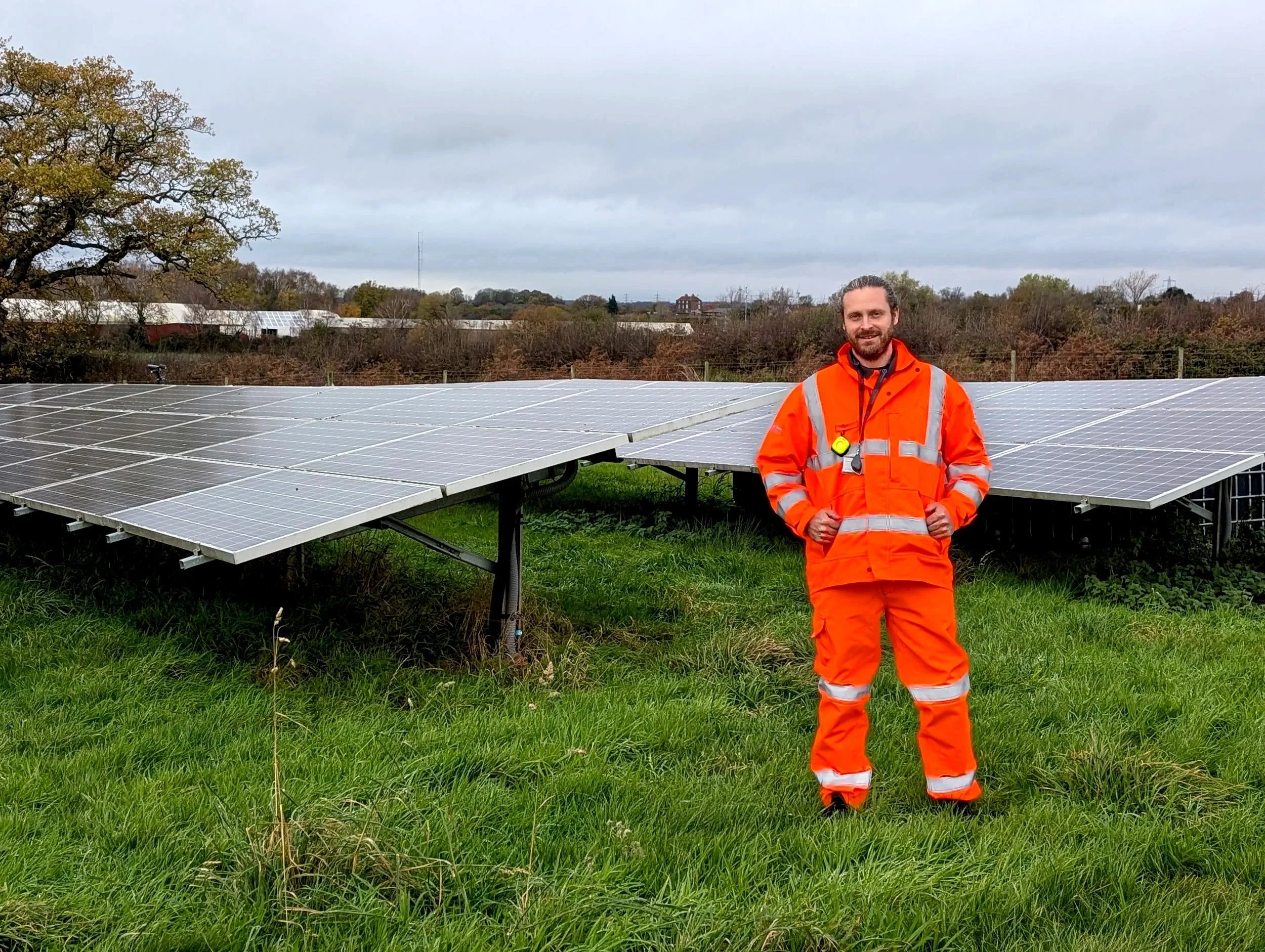 Fire safety consultant in high-visibility PPE at a UK solar farm during a fire risk assessment