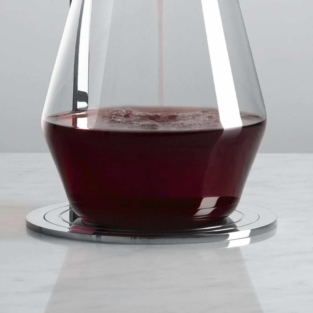 Close-up of a glass of red wine on a white surface, with a reflection of light on the glass.