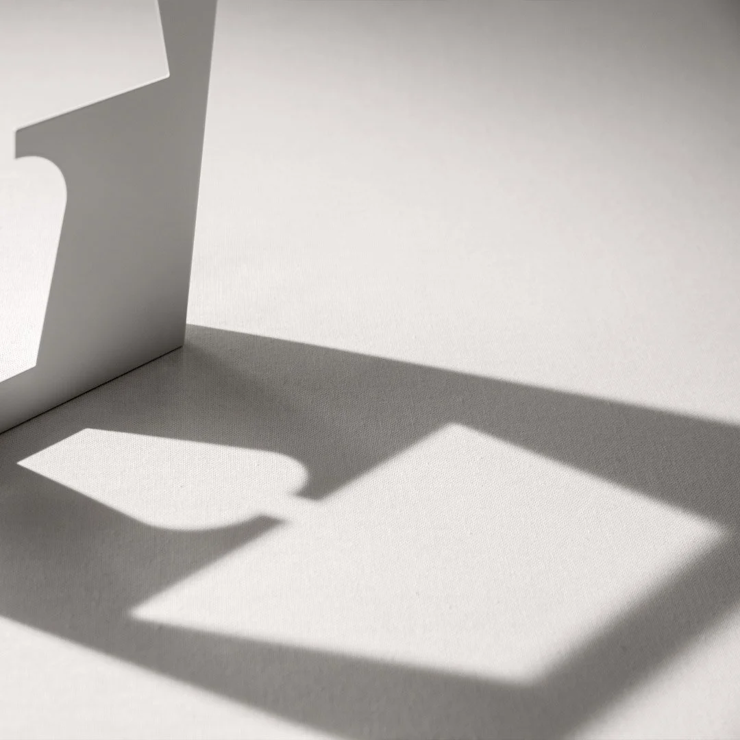 Close-up of a white podium casting a shadow on a white surface.
