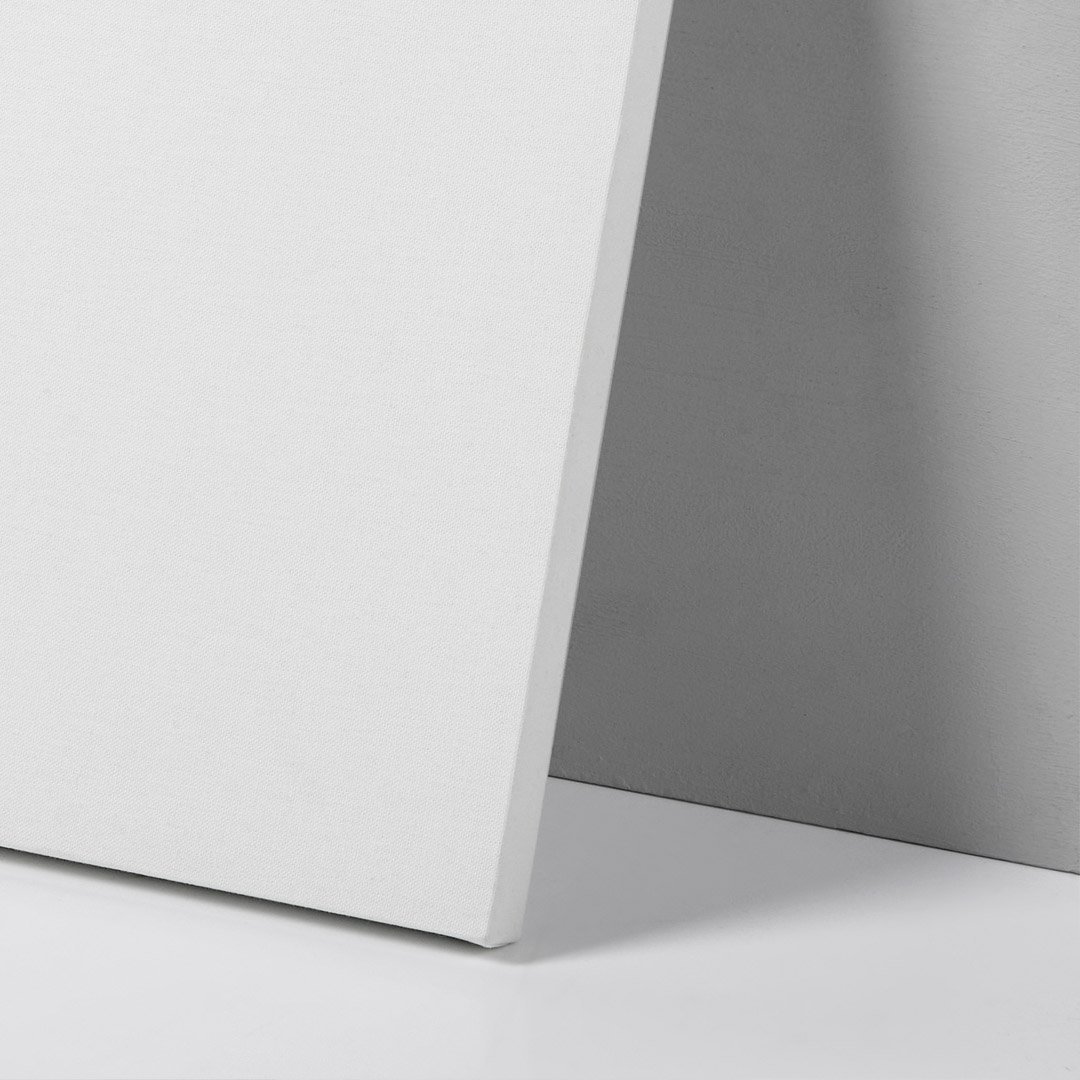 Close-up of a corner of a white textured speaker next to a smooth gray surface.