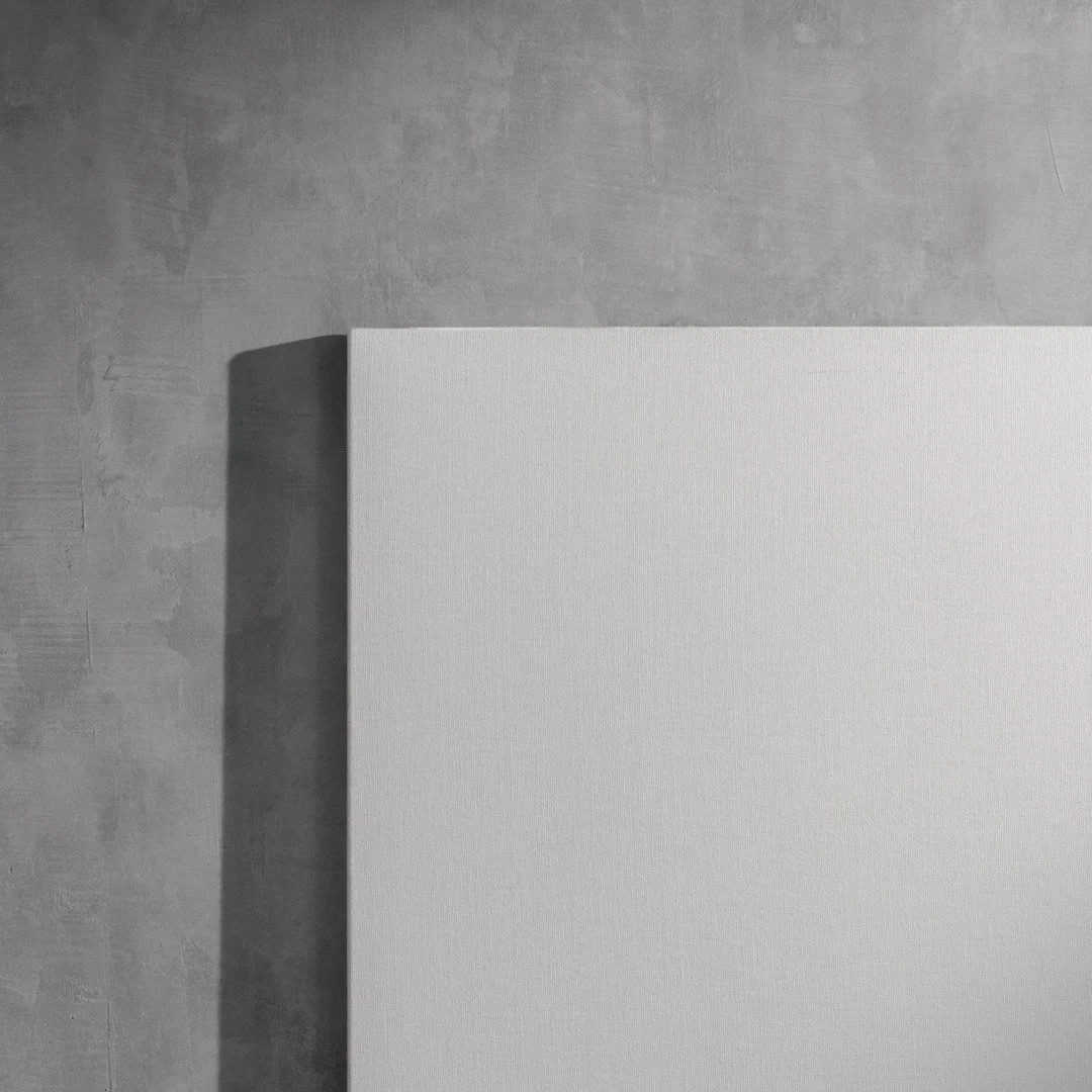 A white canvas or board placed on a gray surface with a shadow cast to the left.